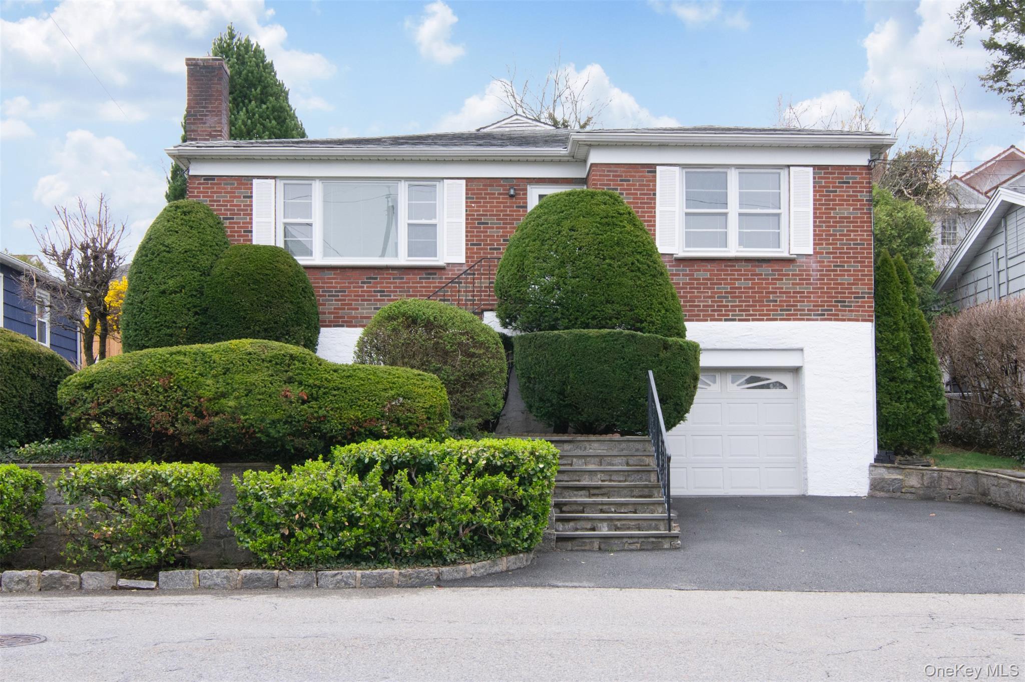 Welcome to 34 Deshon Avenue, a charming home in the heart of the desirable Armour Villa neighborhood, deally located just a short, easy walk to Metro-North and the vibrant Bronxville Village center. The main level features three bedrooms and two full baths, along with an eat-in kitchen, a formal dining room, and a spacious living room all thoughtfully arranged for easy, one-level living.Just off the kitchen, a stone patio overlooks a serene, private yard. Mature plantings including hostas, purple iris, and forsythia—combined with lush, oversized greenery create a peaceful and secluded outdoor retreat.The lower level offers exceptionally high ceilings and provides laundry, storage, and utility space, along with direct access to the attached one-car garage. Thoughtfully maintained over the years, this home is ready for it's next chapter.