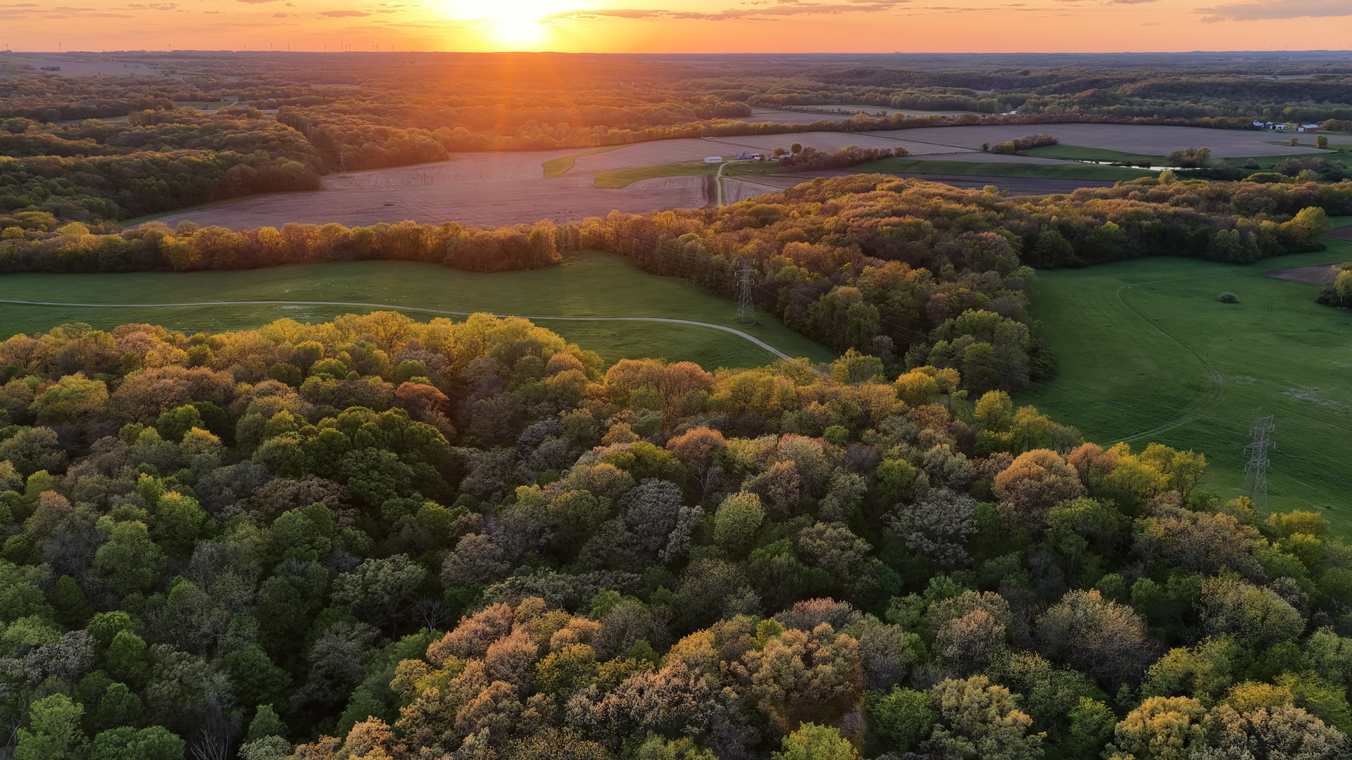 Discover an extraordinary 1,029-acre legacy property in the heart of Bureau County offering a rare combination of income producing farmland with premier recreational opportunities. Over 500 acres of productive tillable ground, this property provides strong agricultural value alongside exceptional natural beauty and privacy.    The farm currently includes approximately 500 acres currently being farmed. The farmed acres hold a blended Productivtu Index average of 123 PI. The current owner will retain farming rigfhts for 2026, 2027 farm tenancy will ne open. There is currently 23.7 acres enrolled in CRP, generating approximately $6,500 annually in income. All CRP contracts relative to this farm expire 2029. Addition too the farmed and CRP acres, there is an additional 80 acres that offers outstanding flexibility and could be farmed, enrolled in CRP, or developed into premium food plots or grasses to further enhance the property's already exceptional wildlife habitat.     Experience the freedom of wide open scenic terrain ideal for horeseback riding, ATV riding, and hiking. Over 2 miles of interior gravel roads that have been well maintained for easy access any time of the year.     A picturesque 9.5-acre stocked lake serves as the centerpiece of the farm, offering excellent fishing for bass and bluegill. There are well -built docks in place. The pond is 25+ feet deep in its deepest locations.  On the North portion of the farm, you will find 1/2 mile of Big Bureau Creek frontage. Addition to the excellent fishing on Bureau Creek, you will find bald eagles, migrating waterfowl, deer and turkey all meandering the historic waterway. The creek is a great camping location and many people enjoy traveling the creek by kayak.   Well-maintained gravel roads provide easy access throughout the entire tract.    The property includes two homes, several outbuildings, and grain storage facilities, making it well-equipped for farming operations, recreational use, or future development opportunities. Multiple picture-perfect homesites overlook rolling countryside, water features, and timbered draws. The farmstead is situated on a dead-end gravel road offering peace and privacy.     Renowned for outstanding whitetail deer hunting, the area consistently produces exceptional wildlife habitat. The neighborhood is all setup with large tract owners. he main artery of the property has south access from 2040 E St. This is a game-changer when you are playing the wind and wanting to move in on a big buck that is living on the farm. Quality deer management is a normal operating practice in the neighborhood, thus allowing giant whitetail bucks to reach their maturity.  With several flocks of wild turkey regularly calling the property home, the spring timber is usually loud with gobbling Tom birds.      Whether you're seeking a productive farm investment, private hunting retreat, or a one-of-a-kind family estate, this remarkable Bureau County property offers unmatched versatility, recreation, and long-term value. Ideally located just two hours from Chicago and only one hour from General Wayne A. Downing Peoria International Airport, this exceptional property offers the perfect balance of privacy, recreation, and accessibility. Whether envisioned as a premier hunting retreat, working farm, or generational family estate, opportunities of this scale and quality rarely come to market in Bureau County.