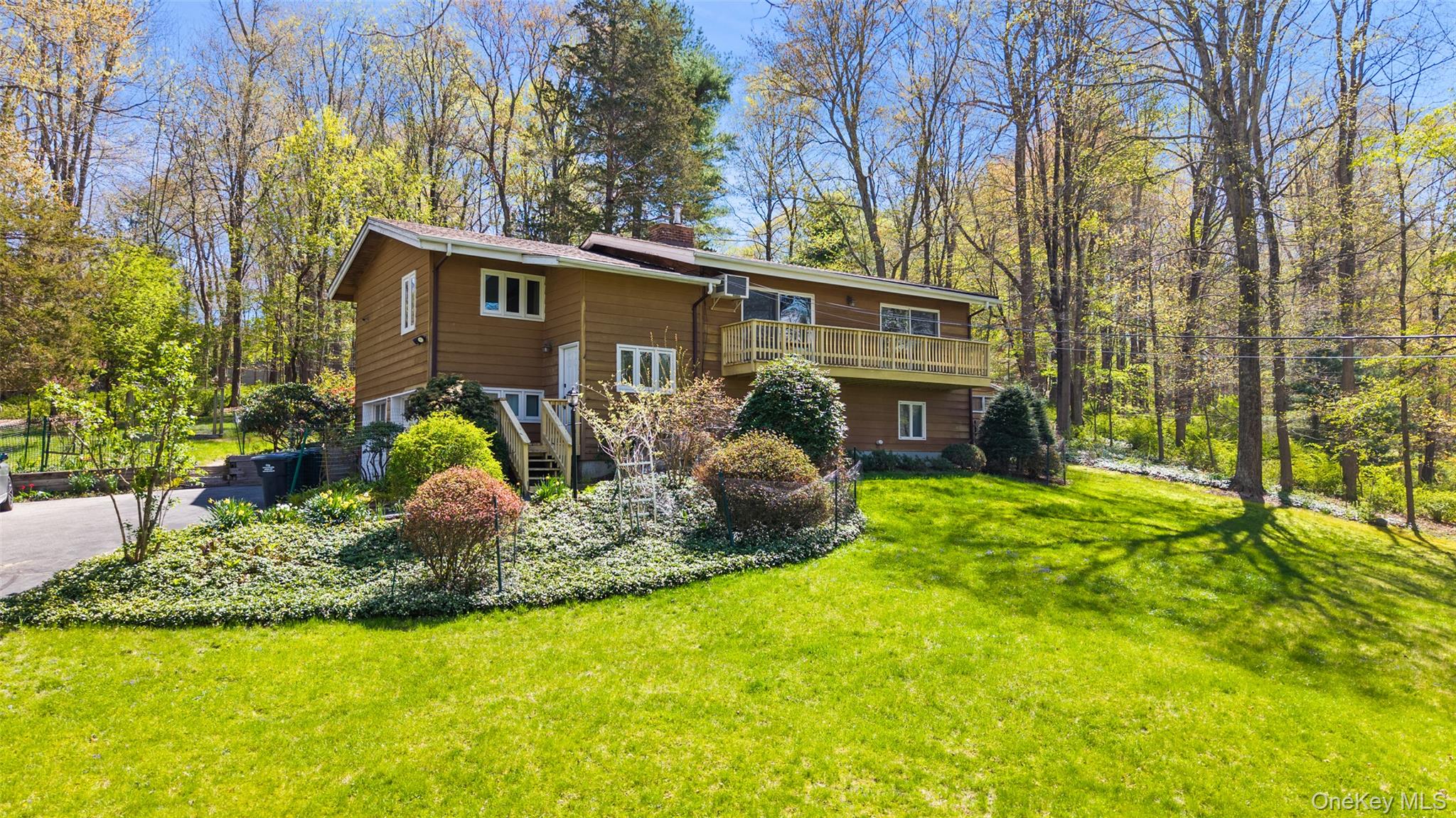 Western View. Over one park-like acre with rolling lawns, flowering plantings and towering trees. First time listed in years, distinctive Country House with elements of a classic deck house. Warm interior spaces with hardwood floors and vaulted ceilings finished in wood. Sun-filled Living Room with fireplace and doors to front deck, ideal for relaxation. Dining Room with vaulted ceiling. Country Kitchen with breakfast room and door to rear terrace. Three Bedrooms. Spacious Lower Level Recreation Room with bar. Most convenient location with easy access to Route 35, Cross River, Ridgefield and commuting arteries. A wonderful opportunity!