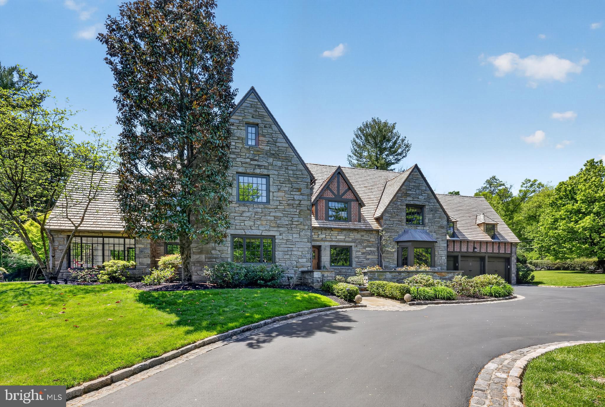 Welcome to 56 Tunbridge Road, a timeless 1930s English Tudor located in one of the Main Line’s most coveted neighborhoods. Over the past 14 years, the home has been meticulously maintained and improved, following a significant renovation designed by Peter Zimmerman Architects 2004–2005. The result is a charming, &  sunny home that has, and will stand the test of time. Upon arrival, two recent upgrades are immediately evident: the new cedar shake roof (2025) and Pella Architectural Windows (2014). A pillared entrance leads to this impeccable 5 bedroom, 4 full and 2 half bath home with an expansive terrace overlooking the  one acre level lawn. Inside is a bright, 3 story center hall colonial with wonderful circulation for entertaining. Many rooms feature Tudor inspired details, hardwood floors, classic millwork, custom built ins, and arched doorways. The first floor includes a foyer opening to the living and dining rooms, all with ornate plaster crown molding & hardwood floors. Off the living room—featuring a fireplace and French doors to the terrace—is a library with hand rubbed cherry paneling & a Mercer tile fireplace. A sunroom with terrace access sits beyond. The dining room offers a bay window, custom wainscoting, &  access to the butler’s pantry/bar. A lighted gallery with limestone floors & three sets of steel French doors leads to the kitchen, powder room, mudroom/family entrance from the garage, & potting room. The kitchen includes custom cabinetry, quartz countertops and backsplash, a large natural oak storage cabinet, large island with refrigerated drawers, Wolf 6 burner cooktop with pasta arm, Wolf double ovens & warming drawer, Bosch dishwasher, Sub Zero refrigerator, & two additional sets of steel French doors to the terrace. Adjacent are the mudroom with home office workspace, coat closet, & potting room with flagstone floor & double sink. A secondary staircase connects to the second floor. The butler’s pantry includes a Sub Zero wine cooler, Uline beverage refrigerator, and access to the full unfinished basement.The second floor includes the primary suite with large bedroom, dressing room with 3 walk-in closets, spacious bath with double vanity, whirlpool tub, shower, water closet, & a separate sitting room. Four additional bedrooms include two with ensuite baths & two sharing a hall bath. The laundry room is also on this level.The finished third floor offers flexible space for an office, studio, playroom, or gym, along with custom cabinetry  & a large walk-in cedar closet. The full basement remains unfinished & includes a half bath and Bilco doors to the backyard.Additional recent improvements include: refreshed kitchen and powder room, newer HVAC systems; boilers (2013 & 2025) for steam, hot water & radiant heat, central air (2022), new gas and water lines, and a Generac whole house generator (2018).This remarkable property offers a rare combination of architectural character, modern updates, and premier Main Line access. Morning walks wind along quiet, tree lined roads past  two of the region’s most storied landscapes: Merion Golf Club - host to many USGA Championships including the 126th U.S. Amateur this August  &  Haverford College’s  Nature Trail, home to one of the nation’s oldest planned collegiate landscapes.  All of this,  in addition to easy access to Haverford and Ardmore SEPTA/Amtrak stations, Suburban Square, top ranked schools, private clubs, and Philadelphia International Airport, confirm this home offers the most exceptional Main Line lifestyle.