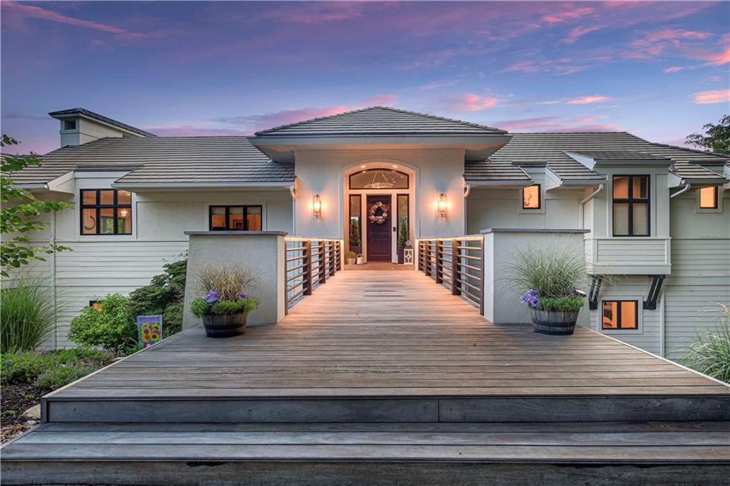 Nestled on an expansive estate lot, this stunning reverse 1.5 story home offers breathtaking lake views and unforgettable sunsets from nearly every room and multiple outdoor decks. Located in the prestigious, gated community of Loch Lloyd, this property offers the perfect blend of privacy, beauty, and potential.

The main level features a fully updated gourmet kitchen with huge island, a Wolf gas range and abundant storage all open to a cozy hearth room with access to the upper deck — ideal for relaxing or entertaining. A charming and functional built in banquette, a walk-in pantry, built in desk, and mud room are bonus features! The living and dining rooms showcase floor-to-ceiling windows that flood the space with natural light and frame the serene lake views. The expansive, open concept layout complements a range of lifestyles — from quiet evenings at home to vibrant entertaining. A true sanctuary, the primary suite boasts sweeping lake views through expansive windows, along with a walk-in closet, an indulgent soaking tub, and a double-sided fireplace that infuses the space with cozy sophistication. The versatile walk-out lower level includes a large family room and three additional bedrooms with private bathrooms—all with lake views. There’s also an impressive 2,809 square feet of unfinished space in the sub-basement, providing endless possibilities for customization—home gym, theater, or additional living quarters.

Additional highlights include gorgeous wood floors throughout, oversized 3-car garage, and a prime lakefront lot measuring approximately 157’ across the front, 181’ at the shoreline, and 325’ deep.

Don’t miss the chance to be part of the vibrant and growing Loch Lloyd community. This is more than a home—it’s a lifestyle.