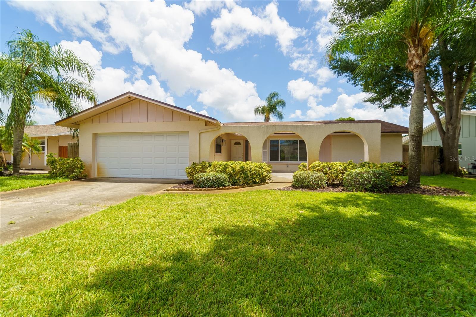 Welcome to this wonderful home in the desirable Woodgate of Countryside neighborhood of North Clearwater, conveniently located just minutes from Countryside Mall and an array of popular shopping, dining, and entertainment options. Situated on a quiet interior street, this home offers a spacious and inviting floor plan with three large bedrooms, two bathrooms, and an oversized two-car garage. The popular layout features a formal living and dining room combination, along with a separate family room that is ideal for everyday living and casual entertaining. The galley-style kitchen offers maple cabinetry and solid-surface countertops. Sliding glass doors from the family room open to a large screened-in porch and fenced backyard, creating a wonderful space for outdoor relaxation and entertaining. The spacious primary suite includes an attached bathroom and a generous walk-in closet, providing plenty of storage. The split-bedroom floor plan offers privacy, with two large guest bedrooms and a guest bathroom conveniently situated between them. Woodgate of Countryside is known for its highly regarded schools and community park with playground. Recent updates include a brand-new shingle roof, water heater replaced in 2022, A/C replaced in 2018, and ductwork replaced in 2019. The home also features an in-ground sprinkler system supplied by a private irrigation well. For added storm preparedness, plywood has been cut and is ready for window protection, and the electrical panel includes an added outlet for a portable generator. A quick closing is encouraged. Come see all this wonderful Woodgate of Countryside home has to offer!