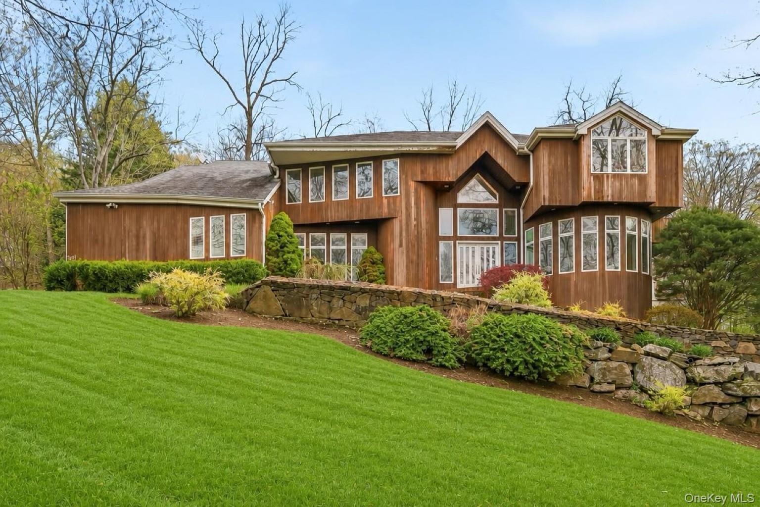 Set on a picturesque property in sought-after Random Farms, this stunning 6-bedroom residence offers dramatic views, soaring ceilings, and exceptional living spaces designed for both everyday comfort and elegant entertaining. A breathtaking double-height entry welcomes you into sun-drenched interiors featuring walls of windows, rich hardwood floors, and seamless open-concept flow throughout.The spectacular great room is the heart of the home, highlighted by oversized architectural windows, a striking fireplace, and direct access to outdoor living spaces overlooking the serene landscape. The spacious chef’s kitchen features extensive custom cabinetry, premium appliances, large center island, and sunny breakfast area perfect for gathering.Designed with flexibility in mind, the home includes a full first-floor guest suite and a private first-floor office with custom built-ins — ideal for today’s work-from-home lifestyle. Additional highlights include elegant formal living and dining rooms, generous secondary bedrooms, and beautifully scaled entertaining spaces throughout. Located within the prestigious Random Farms community offering clubhouse, pool, tennis, and lifestyle amenities, this exceptional home combines privacy, luxury, and convenience just minutes to town, train, and top-rated Chappaqua schools.
