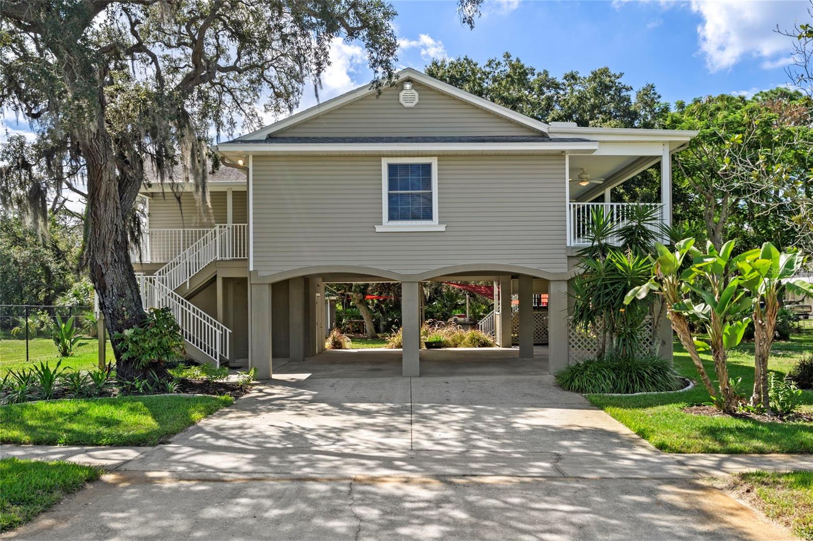Virtually Staged. One-of-a-kind Tarpon Springs home with Gulf views, a double-lot setting, lush landscaping, and an unbeatable location! Tucked at the end of Coburn Drive-a dead end street- this beautifully updated 2-bedroom, 2-bath home offers privacy, character, and plenty of space both inside and out.A covered ground-level carport provides 4 parking spots and a 200 sq. ft. storage utility room. The property features gorgeous landscaping, with mature oak trees and a variety of fruit trees. The deeded lot offers the unique potential to subdivide the second portion of the property, providing an opportunity for future development, subject to applicable approvals and restrictions.Upstairs, an expanded landing welcomes you through the front door into a bright, open-concept living space. Newly installed French doors and an enlarged covered porch that showcase wonderful Gulf views and create the perfect setting for morning coffee, evening relaxation, or watching the world renowned Gulf Sunset. The split-bedroom floor plan provides privacy, while gorgeous wood flooring continues into the primary suite, which also features French doors opening onto the porch and its water views.The updated kitchen combines style and functionality with 42-inch wood cabinetry, a breakfast bar, and vaulted ceilings, giving the home an expansive feel. Thoughtfully updated throughout, this home is move-in ready.A second staircase in the rear of the home, provides convenient access to the backyard, where pavers lead to a custom outdoor entertaining area featuring a large paver patio and an outdoor island with a built in gas grill. A 12x16 shed offers excellent additional storage for recreational equipment, tools, or a workshop. Plenty of room to store the boat for your weekend fishing trip, stone crab hunt, sea cow and dolphin watching, or slow ride to have lunch at the docks.Just minutes from Sunset Beach and Fred Howard Park, with the historic Tarpon Springs Sponge Docks, Greek cuisine, shopping, and waterfront attractions nearby. Enjoy the relaxed Tarpon Springs lifestyle from this special Gulf-view property with room to entertain, garden, store your toys, and enjoy everything the area has to offer.