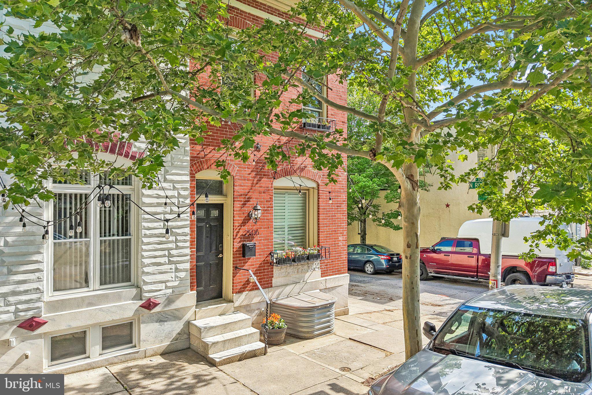 FREE 1 Year Home Warranty through Cinch with purchase! Located just a block from iconic Patterson Park, this stunning oversized Baltimore rowhome perfectly blends modern style with timeless charm. Offering 4 bedrooms and 3.5 bathrooms across multiple finished levels, this home delivers the space, character, and city lifestyle buyers dream about.Step inside to an inviting open-concept main level featuring a cozy fireplace, sleek modern stair design, and an effortless flow between the living area, dining space, and kitchen. Just off the kitchen, step outside to a private deck overlooking a beautifully designed patio retreat, creating the perfect setting for entertaining, relaxing, or enjoying quiet evenings in the city.Upstairs, the spacious front primary suite impresses with elegant tray ceilings and a private ensuite bathroom. Two additional bedrooms and another full bathroom complete the upper level, including a rear bedroom with its own private balcony/deck for a unique outdoor escape.The finished lower level adds incredible flexibility with a fourth bedroom, full bathroom, and dedicated laundry room, ideal for guests, roommates, a home office, or additional living space.With its spacious layout, thoughtful updates, outdoor living spaces, and unbeatable location just a block from Patterson Park, this home offers the perfect balance of classic Baltimore character and modern convenience.  The back patio could also be used as private parking, a rare find in the city!