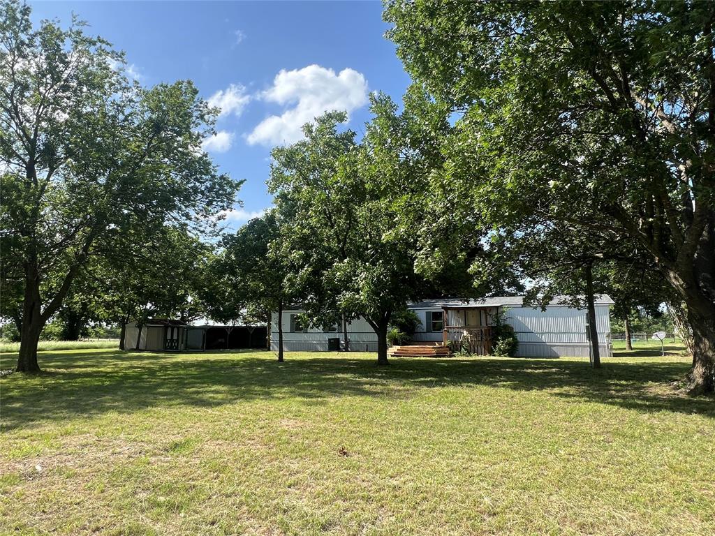 A graveled county road takes you away from the hustle and bustle to your own ranchette on 2.91 acres.  You’ll have plenty of open area for gardening. Mature oak and pecan tress surround the immaculate 3 bedroom, 2 bath mobile home that is move-in ready. The home includes a new roof in 2024, a breakfast bar, stainless steel appliances in kitchen, dining area with patio doors to back deck, 2-car carport, and a front porch. From County Road 4728, you’ll enter through the gate. Country living but still close to city convenience between Greenville and Sulphur Springs!