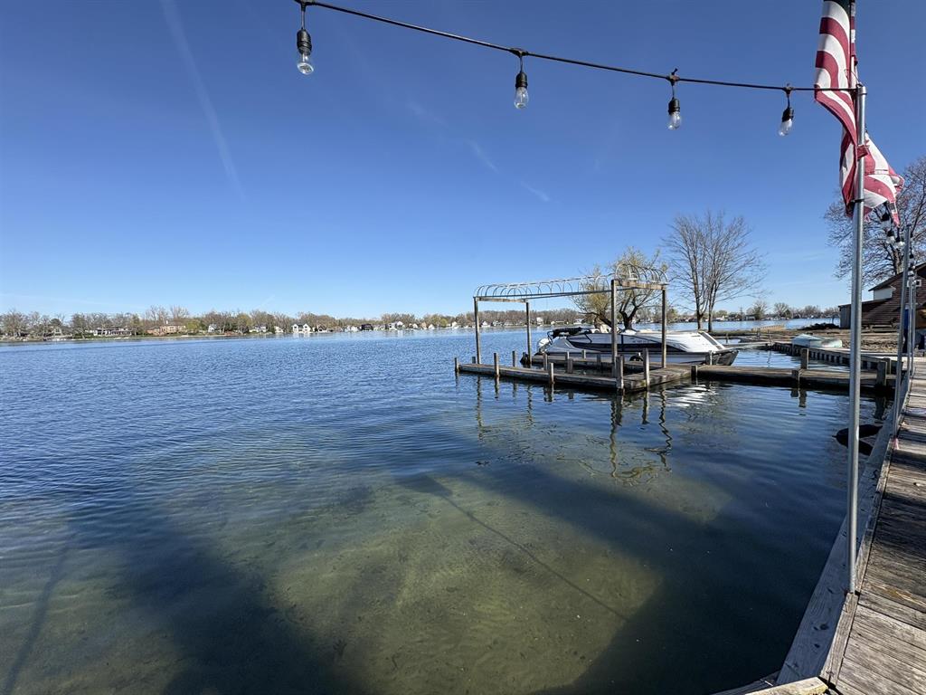 Escape to island living on sought-after Case Island on Lake Fenton! This charming 3-bedroom cottage-style home offers the perfect summer camp feel with sandy beach frontage, a private dock, and peaceful waterfront views in every direction. Accessible by boat only, this unique property delivers the privacy, tranquility, and true "up north" atmosphere you've been dreaming of without leaving Fenton.  Inside, you'll find spacious gathering areas designed for relaxing lake days and entertaining weekends. The oversized primary bedroom features its own balcony overlooking the water, creating the perfect spot for morning coffee or evening sunsets. The kitchen opens to a covered patio for shaded outdoor dining, while an additional lakeside deck provides even more space to enjoy the incredible setting.  Whether you're looking for a seasonal getaway, a place to make lifelong family memories, or a rare island retreat on all-sports Lake Fenton, this property captures the magic of lake life from the moment you arrive by boat.