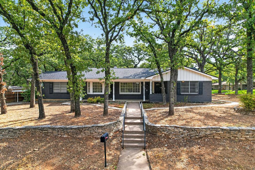 Big on curb appeal, space, and extras! Situated on a HUGE corner lot shaded by mature trees, this 4-bedroom, 2-bath home makes a memorable first impression with fresh exterior paint and beautiful stone landscaping borders. Inside, generous living spaces feature wood-look flooring, neutral tones, abundant natural light, and a painted brick fireplace with a wood mantel. The kitchen offers white cabinetry, granite countertops, a tile backsplash, and stainless steel appliances, while the adjoining dining area features charming bay windows overlooking the tree-filled surroundings. A spacious second living area provides flexibility for entertaining, a game room, or a comfortable everyday retreat. Outside, the expansive stone patio and separate wood deck create inviting spots to gather or unwind. A 2-car garage PLUS a carport and storage shed add convenience that’s hard to find. With room to spread out inside and out, this home delivers character, versatility, and standout outdoor space. Come see everything this corner-lot gem has to offer!