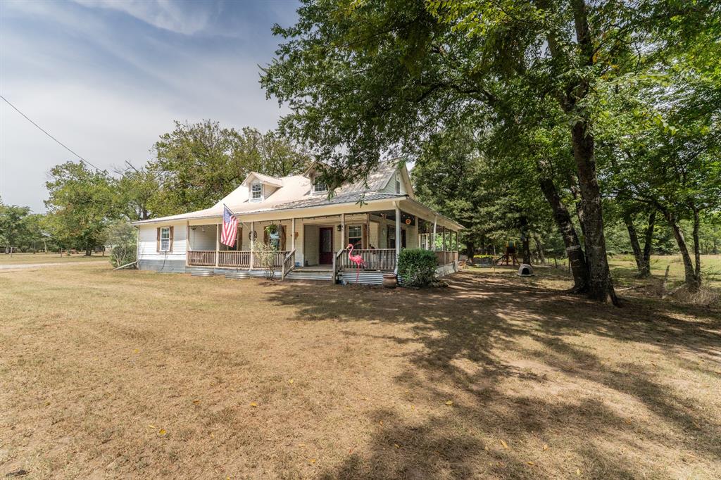 This property features a spacious four-bedroom, two-bathroom home located in Miller Grove ISD, setting on 9.6 acres. Start your morning off on the wrap-around porch enjoying your coffee or enjoy the breeze winding down in the evenings. The home has an open floor plan with a spacious living area, large dining area and a kitchen island. One of the guest bedrooms offers an extra space for an office or reading area. The utility room is conveniently located off the primary suite. You can enjoy country living with a pond stocked with largemouth bass and bluegill. The land features a mix of trees and some pasture providing options for recreation or agricultural use. It's ready for self-sufficient homesteading or farming, the property comes equipped with 26w of solar with 60kwh of storage capacity, a large barn, a dedicated workshop, and a chicken coop. Despite its peaceful, secluded atmosphere, you are not isolated—positioned just 5 minutes from I-30 and a quick 15-minute drive from dining and shopping on the downtown square of Sulphur Springs. Whether you envision casting a line at sunset, cultivating your own garden, or simply enjoying quiet rural starlight, this property offers the ultimate canvas for your dream lifestyle.
