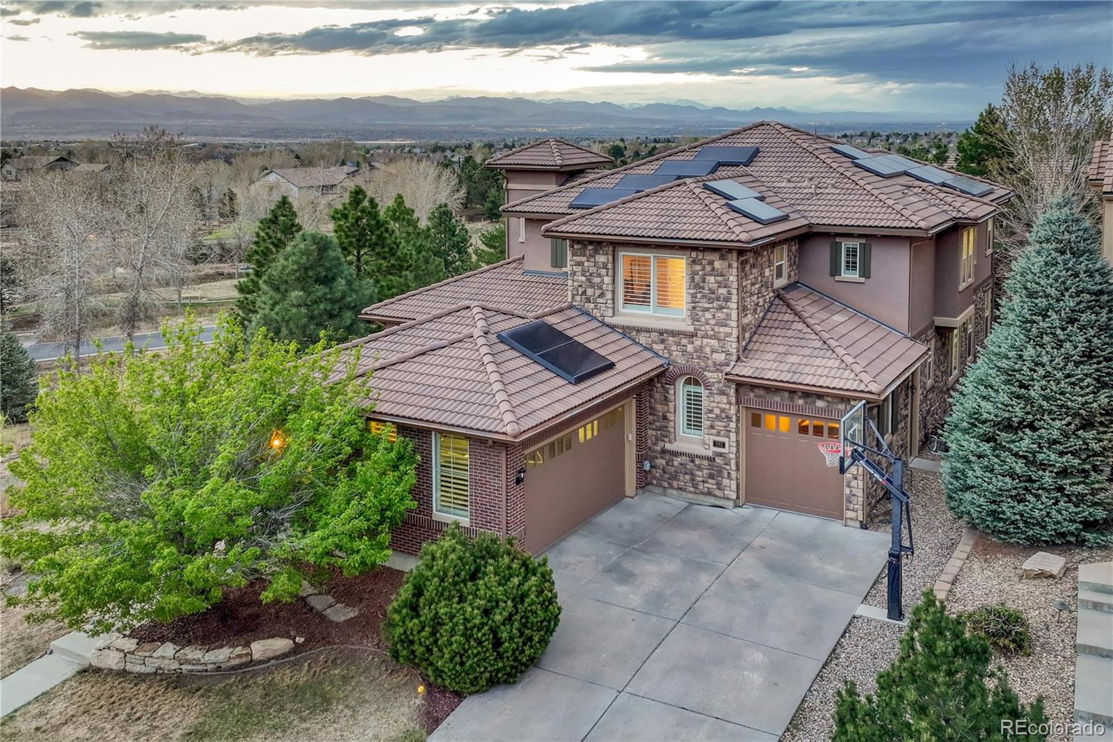 Situated on a desirable corner lot in the sought-after BackCountry neighborhood of Highlands Ranch, 283 Maplehurst Drive offers breathtaking MOUNTAIN VIEWS from the expansive deck and an exceptional blend of modern infrastructure and future design potential. This impressive two-story home features 5 bedrooms and 6 bathrooms, thoughtfully designed for both everyday living and entertaining. Extensive recent upgrades provide peace of mind and efficiency, including paid-off solar panels, two new furnaces, two new A/C units, two heat pumps, a tankless water heater, and a whole-house water filtration system. A stunning finished basement, completed just two years ago adds incredible living space with a structural floor, glass-enclosed workout room, wet bar with beverage fridge and ice maker, home theater with projector and blackout shades, and a private guest suite with ensuite bath. The beautifully landscaped backyard showcases low-maintenance turf, a fire pit, and clean cement edging, while the interior features engineered wood flooring, newer carpet, plantation shutters, and Sonos-controlled surround sound throughout. The functional layout includes a main-level bedroom with a three-quarter bath, a spacious primary suite with dual custom closets and pass-through laundry, and two additional upstairs bedrooms each with private ensuite baths. The kitchen has a large island, lots of additional counter space, large walk-in pantry, complemented by newer appliances, including a new range, refrigerator and dishwasher making this home a rare opportunity to own a structurally upgraded, energy-efficient property in one of Highlands Ranch’s premier communities. The Backcountry neighborhood features a pool, clubhouse with restaurant and bar, community space, workout room, amphitheater, hiking and biking trails, coffee shop and amazing community events throughout the year for all ages.