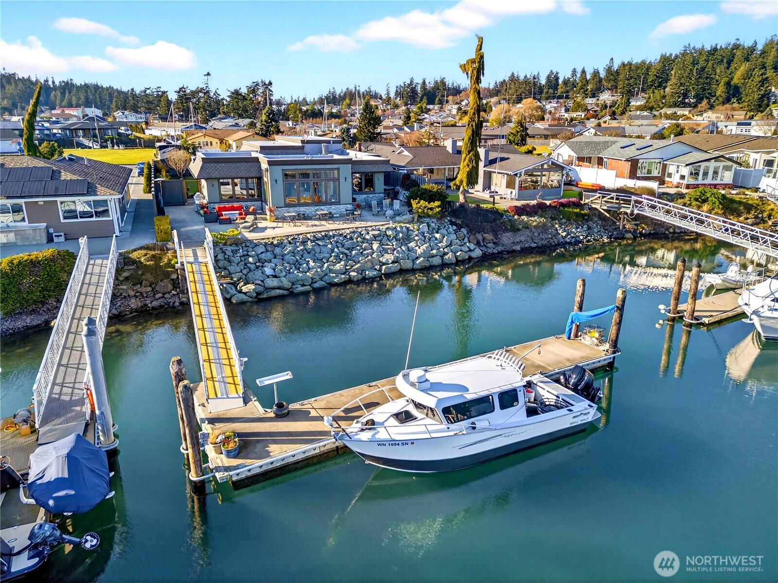 Experience premier waterfront living in the heart of Skyline with this beautiful single-level home offering private moorage and exceptional craftsmanship. With approximately 70+/- feet of low-bank saltwater frontage and a 50+/- foot double-sided private dock, there’s room for your yacht, fishing vessel, and all your waterfront adventures. Designed with an open-concept layout, the home lives effortlessly, blending expansive living spaces with sweeping marina views. Two luxurious primary suites provide flexibility and comfort—one featuring a spa-inspired bath with a steam shower and jetted tub for a true retreat experience. Copper-clad wood windows frame the water views, while copper gutters and downspouts add distinctive architectural detail and long-lasting quality. A generous craft room with custom built-ins offers creative space rarely found in waterfront properties, and a thoughtfully designed office with built-in cabinetry captures beautiful marina views—ideal for working from home without missing a moment of the scenery. Car enthusiasts and travelers will appreciate the attached 2-car garage plus an additional bay sized for a 45+/- motorhome or boat, along with exterior RV parking. All of this is located just about 70 minutes from Seattle. This is Pacific Northwest boating lifestyle at its finest—private dock, protected moorage, and refined one-level living in one extraordinary package!