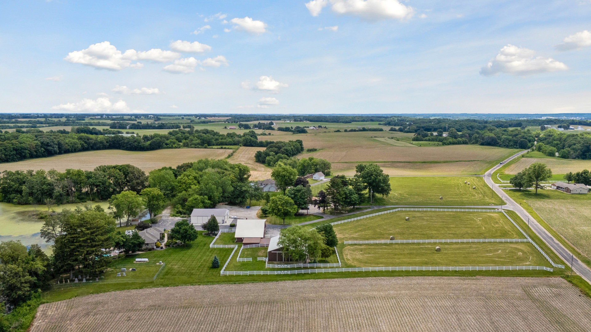 Rare opportunity to own an exceptional 15-acre farmstead offering endless possibilities for horse enthusiasts, car collectors, hobby farmers, or anyone seeking the ultimate country lifestyle. Comprised of three parcels, the property features two homes, four outbuildings, farm pond views, hayfield, extensive parking, and hard-surface access throughout.    The custom ranch home, built in 1995 by Hazelwood Homes, offers 2 bedrooms, 3 baths, an open floor plan, heated 2-car garage, finished walkout basement ready for expansion, backup generator, heated above-ground pool, four-season room, and multiple covered patios and decks overlooking the picturesque countryside.    Equestrian amenities include a 60x40 steel-sided horse barn with 7-8 spacious 12'x11' stalls, a 23'x11' climate-controlled tack room, 60'x12' covered porch, and large fenced pasture. The FULLY climate-controlled 60x40 pole building is an entertainer's dream featuring a bathroom, kitchenette, and a party bar area with additional HVAC system. A 60x40 steel-sided machine shed and large lean-to provide abundant storage for equipment, vehicles, toys, or livestock.    Need space for family, guests, rental income, or farm help? The property also includes a well-maintained 4-bedroom, 2-bath farmhouse with a 2-car garage.    With blacktopped lanes, numerous Iowa hydrants throughout the property, incredible parking capacity, and room for nearly any hobby or business venture, this one-of-a-kind property truly checks every box. Properties of this caliber and versatility rarely become available-don't miss your chance to own this Port Byron unicorn.