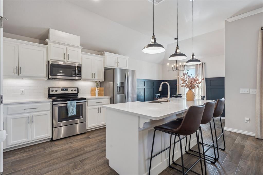 This thoughtfully designed open floor plan home features custom details that set it apart within the neighborhood. From the moment you enter, upgraded lighting, wood-look tile flooring, and a spacious living area create a cohesive and inviting atmosphere. Two secondary bedrooms with a shared bath are positioned at the front of the home, offering both functionality and privacy.The kitchen is designed for everyday living and entertaining, featuring stainless steel appliances, barstool seating, and a pantry, all open to the main living space. The primary suite is privately situated on the opposite side of the home and includes a custom built-in desk with ample storage. The en-suite bath features dual sinks, a large walk-in closet, a walk-in shower with upgraded glass enclosure, and a soaking tub.A covered patio and generous backyard extend the living space outdoors. There is also a STORM SHELTER in the garage floor! With convenient access to Lake Hefner Parkway and the Kilpatrick Turnpike, this home offers a balanced blend of thoughtful design and accessibility.