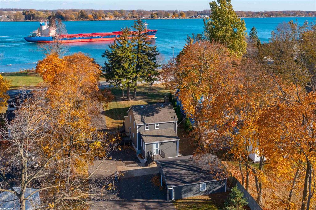 Experience serene waterfront living in this updated 4 bedroom home along the stunning St. Clair River. Step inside to an open-concept kitchen featuring stainless steel appliances, barstool seating, and a seamless flow into the bright and airy great room. Large windows fill the space with natural light and showcase captivating river views, creating a warm and inviting atmosphere. A spacious first floor bedroom and convenient laundry add practicality, while upstairs you'll find three additional bedrooms and a full bath. The attached two-car garage offers plenty of storage space. Relax on the porch and take in Michigan's finest sunrises and sunsets, or enjoy endless water activities such as fishing, boating, and peaceful walks along nearby paths and parks. Cottrellville Township Shoreline Park is just across the street, providing direct access to the river. Recent updates since 2023 include new siding, gutters, driveway, Trex-style deck, high-efficiency 90+ furnace, and more-making this home move-in ready and worry free. Conveniently located near restaurants, shops, and recreational spots, this riverfront gem perfectly blends comfort, style, and location.