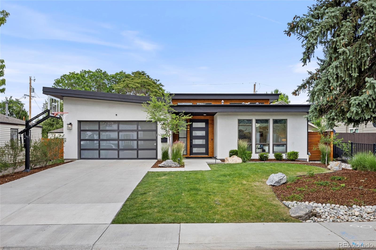 Highly sought-after 5-bedroom, 5-bathroom Mid-Century Modern ranch offering 4,832 square feet in University Hills, just steps from Eisenhower Park, featuring iconic clerestory windows that flood the home with natural light and enhance its timeless architectural appeal. Enjoy your own private backyard oasis, with a heated in-ground swimming pool, relaxing in-ground hot tub and low-maintenance turf yard. The inviting patio living area is anchored by a stunning outdoor/indoor fireplace that creates a lounge-like atmosphere for alfresco gatherings and year-round entertaining. The chef’s kitchen is an entertainer’s dream, showcasing waterfall countertops, premium Thermador appliances including a 30-inch refrigerator, 30-inch freezer, built-in wine refrigerator, integrated barista station, 48-inch range with steam oven, warming drawer, and drawer microwave; all thoughtfully flowing into the open living room space. The main-floor primary suite is privately located on the North side of the home, overlooks the calming pool and backyard, offers automated window coverings, an equipped custom Colorado Closets walk-in closet, and a spa-inspired five-piece bath complete with a Japanese bidet. The finished full basement provides expansive living and recreation space ideal for family hang out space and entertaining, complete with a bar and beverage refrigerator, microwave, included television and three storage areas.This exceptional Mid-Century Modern home combines timeless architecture, luxury amenities, and an unbeatable location in one of Denver’s most desirable neighborhoods.