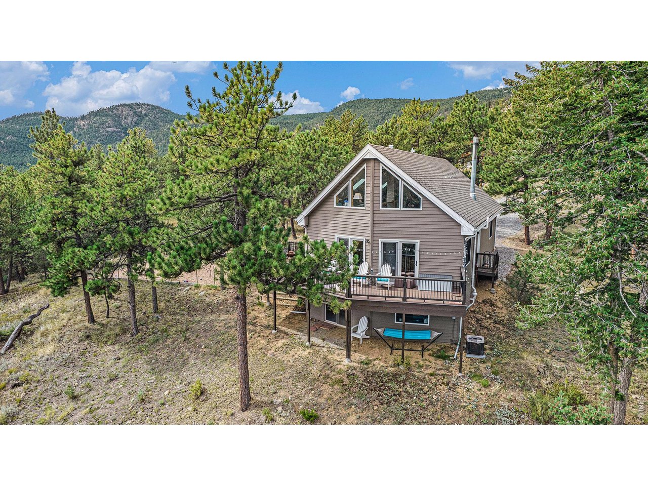 Escape to your own private mountain retreat in Pinewood Springs! Lots of windows, soaring ceilings, and a spacious deck allow you to take in the beautiful mountain views. A rare find with central heat and air conditioning. Step inside to a spacious open floor plan with wide-plank oak floors, soaring cathedral ceilings, granite countertops, and a cozy wood stove. The loft offers exceptional flexibility as an office, yoga or music studio, reading retreat, or other creative uses, all while enjoying some of the home's best views. Nestled among towering pines on a quiet Cul-de-sac with National Forest access nearby. Enjoy all the perks of living in peaceful Pinewood Springs, away from the chaos and crowds. This home is served by its own private well, recently inspected by Johns Well Service, providing added peace of mind. More than just a home, this is a place to slow down, reconnect with nature, and enjoy mountain living at its best. Conveniently located between Estes Park and Rocky Mountain National Park to the west, and the shopping, dining, and everyday conveniences of Longmont and Boulder to the east.