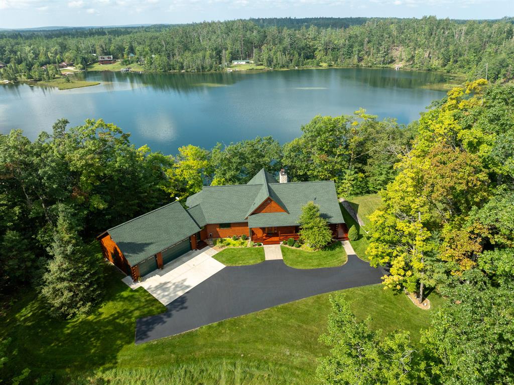 A Northern Michigan Escape Like No Other
Follow the winding drive through the trees and you'll find your private paradise on Long Lake. This 10.62-acre estate blends comfort, style, and recreation in one incredible package. The 4,568 sq ft luxury home features 5 bedrooms, 2 full and 2 half baths, soaring cathedral ceilings, and a grand stone fireplace. The kitchen, dining, and sitting areas are made for gathering, while the primary suite offers a quiet retreat with dual walk-in closets and beautiful bathroom. A walkout basement adds a workout room and extra living space.
Step outside to a sprawling deck overlooking 250+ feet of crystal-clear lake frontage. On the grounds, you'll find a 2,200 sq ft pole barn with man cave, a guesthouse/playhouse, basketball court, batting cages, and a dock ready for summer fun.
Long Lake is a nearly 300-acre all-sports lake, perfect for fishing, swimming, and boating, with depths reaching 90 feet. State land adjacent makes for excellent hunting, hiking, and trail riding are right out your back door.
Whether it's your forever home, a weekend retreat, or the ultimate lake house, this property delivers the full experience.