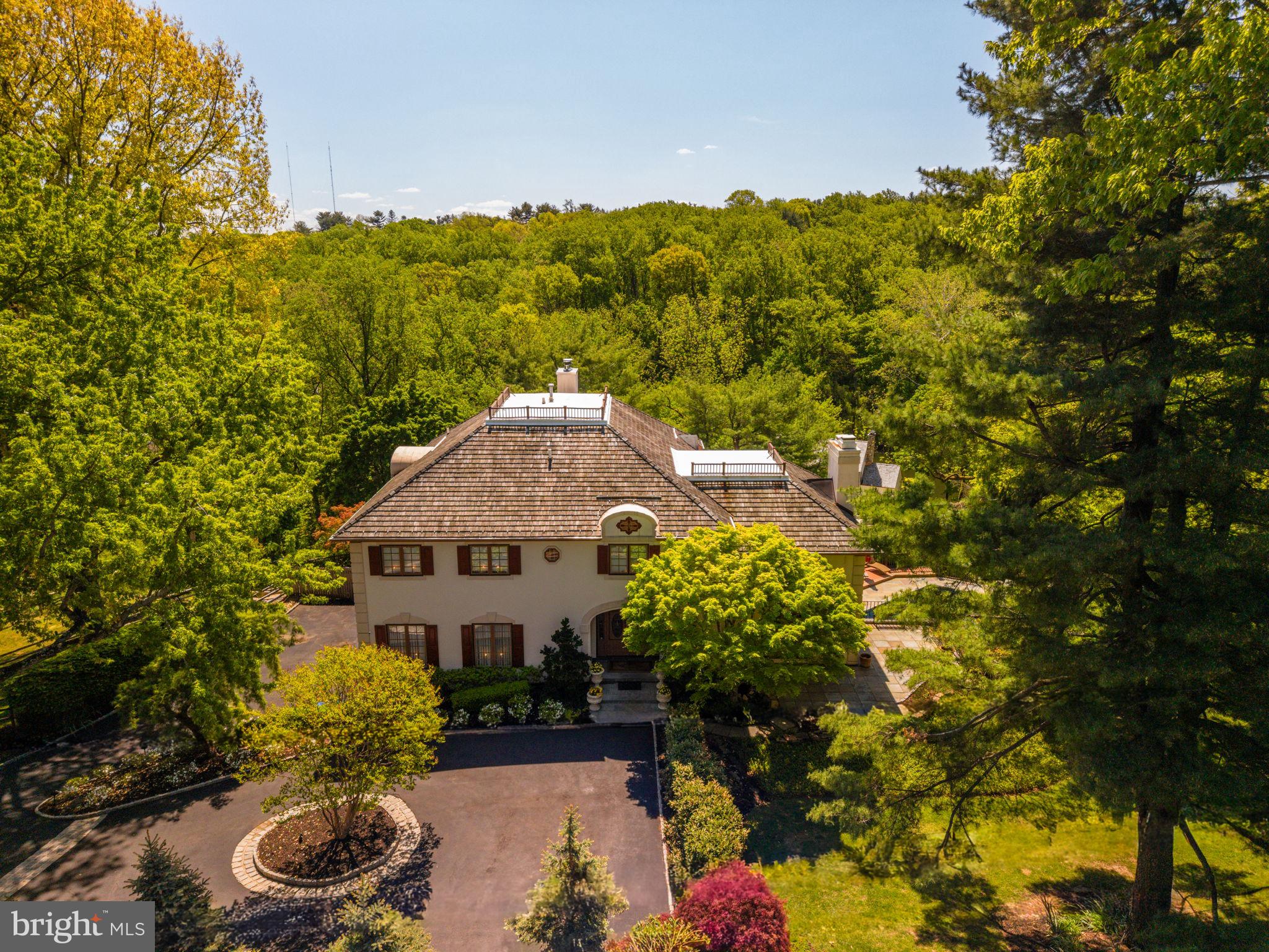 A lighthearted warmth invites you into 1533 Briar Hill, where the quintessential Main Line lifestyle awaits. Meticulous grounds and a sparkling exterior capture you from the driveway. Inside this luxurious estate unfolds across three levels built to suit large gatherings and intimate family living in the heart of the Main Line. A dramatic entry hall with a vaulted ceiling and curved staircase immediately reveals the refined presence and impressive scale of this classic home. Soaring ceilings continue throughout formal and informal spaces, all of which flow seamlessly and create an airy feel. The recent sunroom addition was built by the original architect to bring abundant light and a year-round connection to the serene landscape. A substantial family room accompanies the eat-in kitchen and connects to a deck with sweeping views of Gladwyne.The finished lower level spans a game and recreation room that opens to the resort-style jacuzzi and pool. A private guest suite and 4-car garage are replete with comfort and utility. Upstairs is highlighted by an enormous primary suite and 4 additional bedrooms with beautifully updated bathrooms. Seller's rigorous maintenance schedule extends to various updates and improvements. This is a rare opportunity to own a distinguished, turn-key residence in one of the most beautiful locations in Pennsylvania. Contact Garrett Snider/The Lavinia Smerconish Team at Compass.