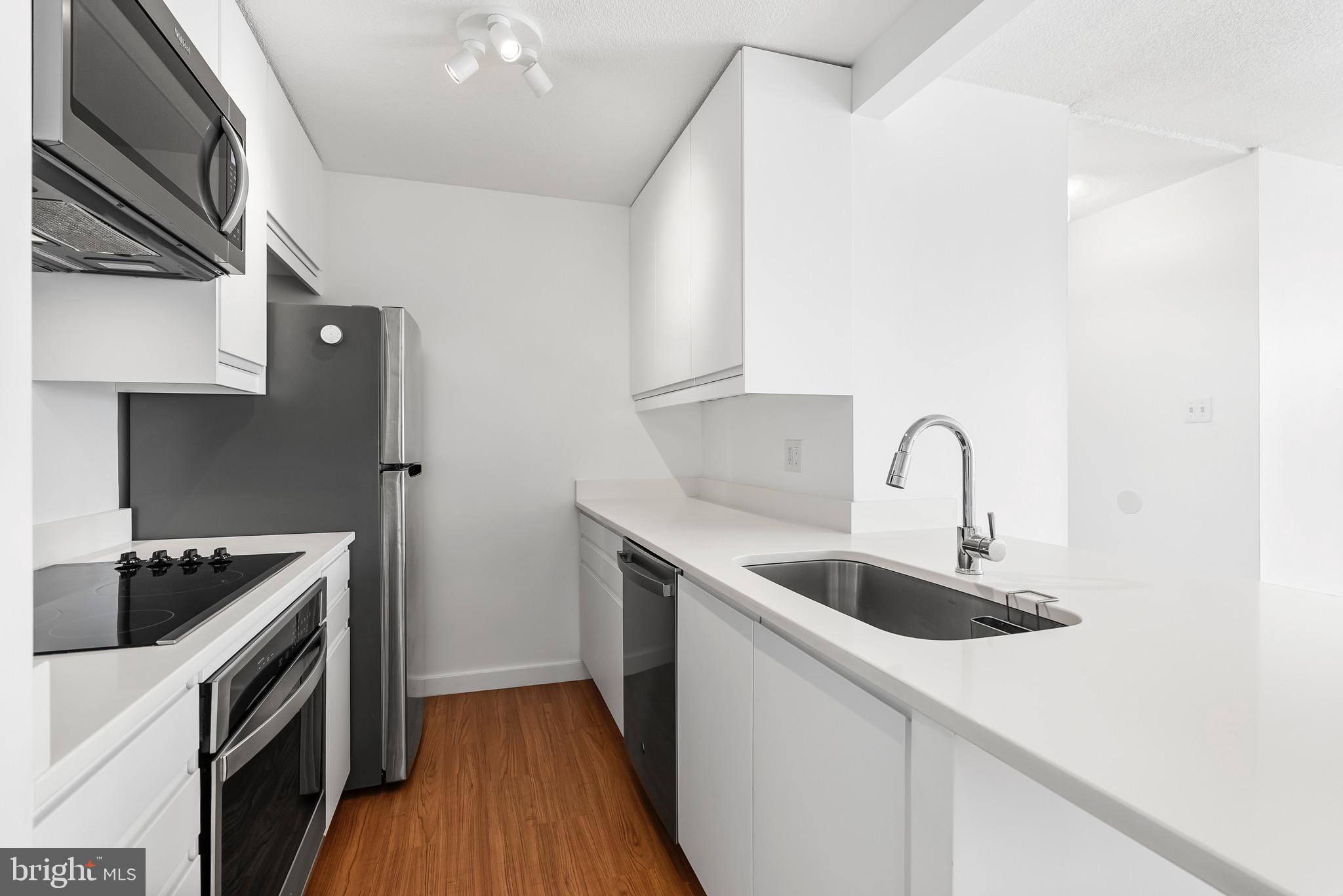 Experience elevated urban living in this beautifully renovated 1-bedroom, 1-bath condo in the heart of Mount Vernon. Perched on the 7th floor of a secure, doorman building, this stylish unit blends historic charm with modern upgrades. the unit has since undergone a complete transformation. The kitchen has been fully transformed and reimagined with sleek under cabinet lighting, an electric cooktop, built-in oven and microwave, dishwasher, and garbage disposal, creating a space that’s both functional and elegant.Refinished hardwood floors run throughout the unit, enhancing the warm and inviting atmosphere. The bathroom has been completely remodeled with granite tile floors, a new sink and countertop, a backlit mirror, and a classic tub/shower combo. A custom brick accent wall adds a touch of industrial style to the space. The bedroom and living room are both outfitted with solar shades, offering privacy while still allowing soft, natural light to pour in.Comfort is key with a brand new HVAC system installed in 2020—a Carrier 1.5-ton 14 SEER heat pump with a smart Nest thermostat—recently serviced in January 2025. The water heater shutoff valves were also replaced in April 2025, giving peace of mind to the next owner. A dedicated storage unit (#6) is conveniently located on the same floor, and parking is available for a monthly fee in the garage directly beneath the building.The building itself offers 24-hour doorman service, an on-site convenience store, and a comprehensive HOA that currently includes water, trash, building insurance, and common area maintenance.  Situated in one of Baltimore’s most walkable and culturally rich neighborhoods, this condo places you just steps from restaurants, cafes, museums, and transit—making it an ideal home for city lovers, first-time buyers, or savvy investors alike