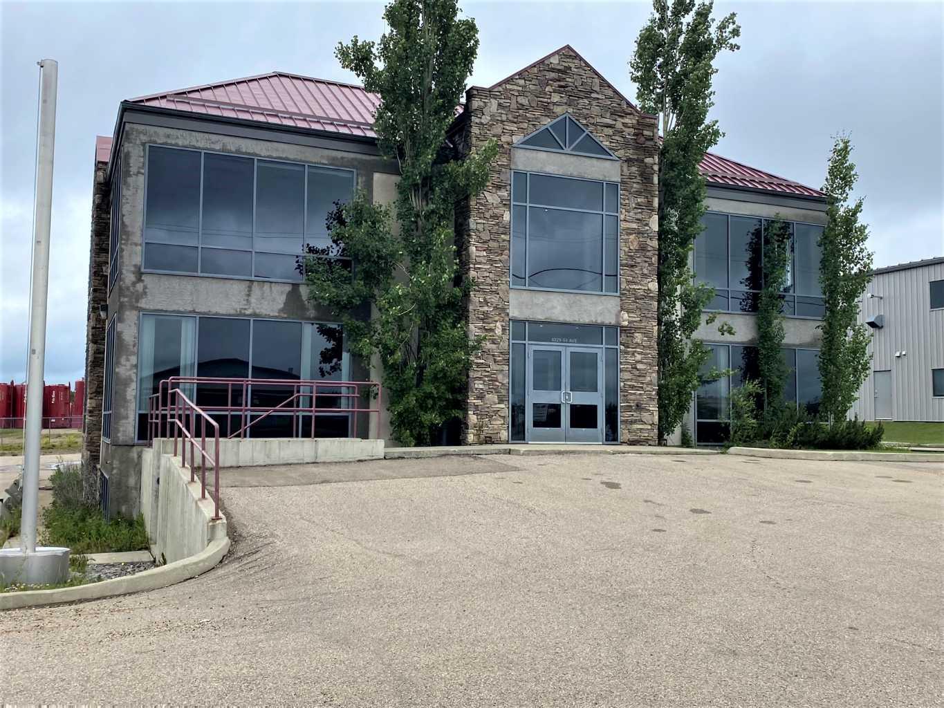 This striking two-story office complex boasts a functional full basement and a heated garage with three bays. The main floor features a welcoming reception area that is surrounded by 9 offices, a lunchroom with a kitchenette with access to patio, storage room, mens and womens washrooms. Upstairs, you'll find a boardroom equipped with a kitchenette, more offices, storage room, mens and womens washrooms.  The offices on the upper level include two executive offices and a room with vaulted ceiling that all offer access to a balcony. The basement is designed for functionality, featuring a spacious crew meeting room with a kitchenette, an exercise area, restrooms with showers, a large fireproof vault, a mechanical room, and ample storage space. The heated garage is conveniently accessible from within the building, and there is paved parking available. Ideally situated in Brazeau County, on the western edge of Drayton Valley, the property is close to all local amenities. The back portion of the lot serves as an open, unserviced fenced storage area that has been rented separately from the office and is currently on a month-to-month agreement without a written contract. . The office has a leasing potential of $25,000 triple net per month, and the seller is open to considering lease offers