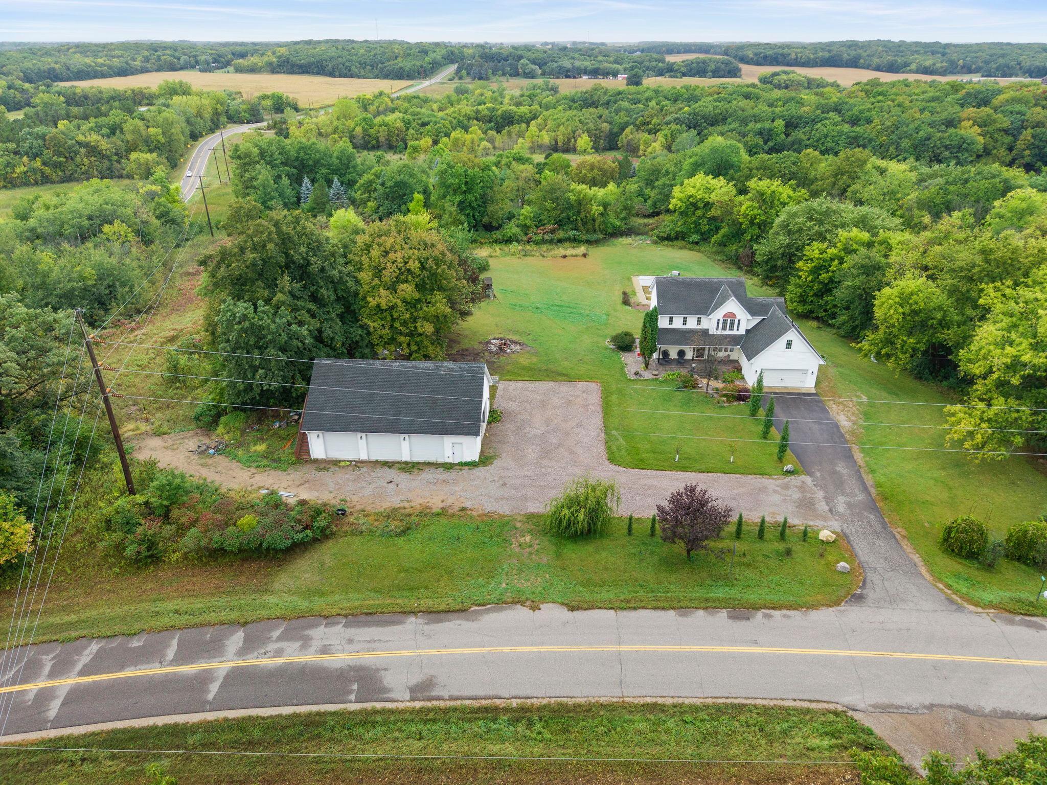 This beautiful 2005 built Two Story home is located on 14.09 acres with lake front, lake view and a pond. The home features 3860 FSF, 5 bedrooms, 4 bathrooms, 2 car attached garage and 32 x 48 outbuilding with heated/insulated/concrete floor with 4 room upstairs and inground heated pool in backyard. The main floor has a covered front porch, open foyer, hardwood & tile floors, spacious living room, formal dining room, kitchen with custom cabinetry, granite counter tops, center island, stainless steel appliances, deck overlooking the lake and large backyard, master suite with walk in closet, master bathroom with double sinks, separate shower & jetted tub and main floor laundry with sink and custom cabinetry. The upper level has 3 bedrooms, a full bathroom and a large loft. The basement features a large family room with walkout to the patio, landscaped yard and outdoor inground pool, a 5th bedroom, 1/2 bathroom, utility room and bonus room. Updates include new flooring on main level, new pool liner & more. The home has panoramic views, is close to town, shopping, schools, community center & golf course.
