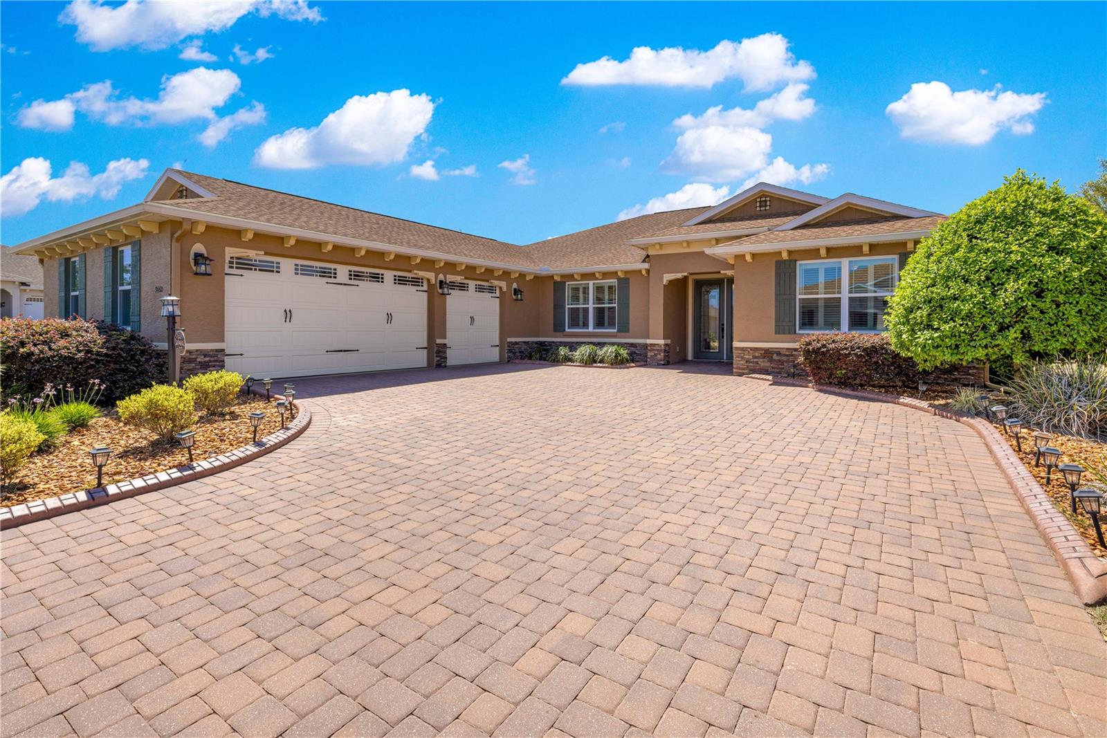 One or more photo(s) has been virtually staged.  BETTER THAN NEW HOME ON PREMIUM LOT!  Private corner lot with a  view of the Golf Course.  Step inside a home that effortlessly outshines new construction—thoughtfully upgraded, meticulously maintained, and barely lived in exceptional 3 bedroom residence could easily be a 4 or 5 bedroom, and offers 4,461 square feet under roof.   The North Hampton Model is the perfect  blend of expansive living spaces with refined finishes and a highly functional layout designed for both comfort and style. From the moment you enter, you’re welcomed by soaring tray ceilings, elegant crown molding, and an abundance of natural light that highlights the home’s open-concept design. The great room flows seamlessly into a chef-inspired kitchen, where upgraded pull-out cabinetry, granite countertops, stainless steel appliances, and designer lighting create a space as beautiful as it is practical. The primary suite is a private retreat, featuring a tray ceiling, and a spa-like ensuite bath with dual vanities, a spacious walk-in shower, and 2 walk-in closets with custom built-ins. Two additional bedrooms provide comfort for guests, while the versatile flex room offers the option of a fourth bedroom, home office, or hobby space. A separate library/den adds yet another layer of flexibility, ideal for quiet reading or a dedicated workspace. Designed to embrace indoor-outdoor living, the home features a newly added, screen-enclosed lanai—perfect for enjoying morning coffee or evening relaxation in a serene, private setting. The covered lanai/sunroom with luxury vinyl flooring extends your living space year-round, making it ideal for entertaining or simply unwinding. Additional highlights include a spacious 3-car insulated garage with custom cabinets, an indoor laundry room with custom built-in cabinetry and sink, plantation blinds throughout,  whole-house gutters, concrete landscape curbing, attic fan, and a Generac whole-home generator. Screen-enclosed lanai has also been added for an extension of the living area.  Every detail has been carefully curated, making this home truly move-in ready without the wait or added expense of builder upgrades. Located in  Candler Hills / Stonebridge, tucked in the highly sought-after 55+ community of On Top of the World.  Residents enjoy access to an array of resort-style amenities and clubs, fostering an active and social lifestyle. Additionally, Candler Hills residents have private access to The Lodge which provides over 18,000 sf of enjoyment including a resort-style pool featuring beach entry and separate spa, covered pavilion, indoor gathering lounge, ballroom, catering kitchen, and much more. Candler Hills features a par 72 championship golf course, and tons of clubs and activities. This is more than just a home—it’s a turnkey opportunity to enjoy elevated living in a vibrant, amenity-rich setting. A rare offering that combines like-new condition, premium upgrades, and immediate availability—this home is ready to impress even the most discerning buyer.