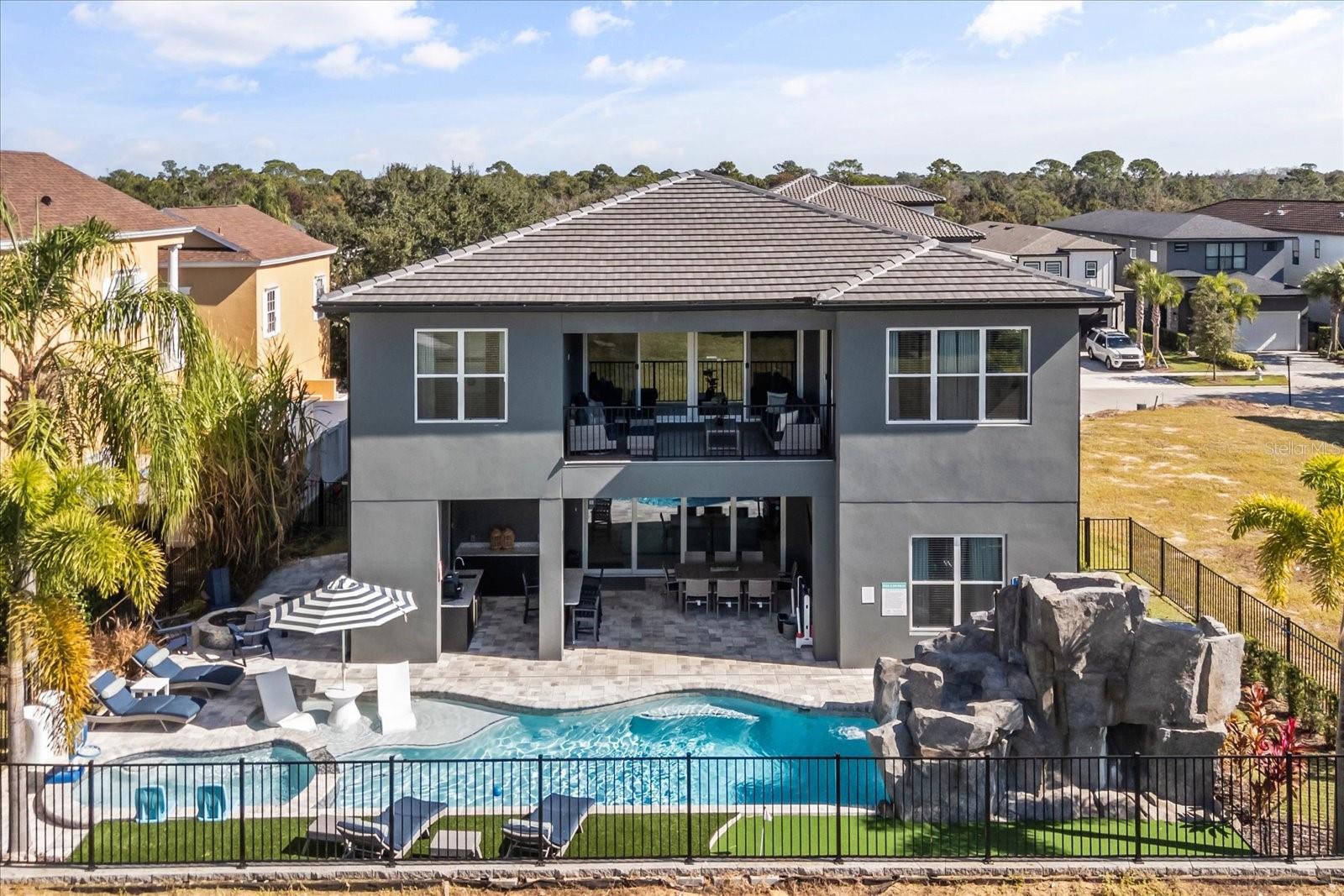 A WATER SLIDE? OPEN 03/25-03/26 TO SHOW*** Home offered with a REUNION RESORT MEMBERSHIP*** This 6 bedroom 6 ½ bathroom property has everything you never knew you always wanted and then some.  This double lot build property is located in the most researched community in the Disney Corridor, Reunion Resort, and now you have a chance to call it your own.  A custom-built 2024 home with over 5800 square feet of entertainment space, luxury finishes, custom theming and a WATERPARK in the backyard! Appliances, flooring, and color palettes were all designed and very well thought out.  A complete TURNKEY OPPORTUNITY with "$" on the books for 2026 reservations.  Please look at the pictures at least 3 times to take it all in.  Pictures 4 and 22 are my favorite.  Pulling into the oversized drive, you know you have arrived. The homes large double doors and entrance are just the start of welcoming you to the open floor plan. Once inside, the home then wraps its arms around you and invites you to see more. Clean, fresh and Florida Perfect, this home makes sure not an inch is wasted.  The living space is comfortable, the kitchen is large and versatile, the dining room space is a great jumping point off for the day, or the place a family gathers around at night to recount the events of the day.  The first floor is complimented by two master suites that are well thought out and include custom design features.  If you love Florida living remember it’s not only what’s inside, but it’s also about what’s outside.  The outside space of this home is like none other in the resort and comes with its very own pizza oven!! Included in the outdoor space is a custom water slide and GROTTO, a sun-lovers dream ray catching area, a putting green, a fire pit, tons of paver patio space, a covered outdoor kitchen area, and just the right spot to grab an afternoon snooze.  REUNION HAS IT'S OWN STADIUM and it fits perfectly into this oversized garage space.   With VIP seating, every sports arcade game you can think of, a custom slide and THE ONLY REUNION JUMBO-TRON, this property has it all under the same roof.  If you are still reading this- yes there is more!  The second story is more impressive than the first.  Adults deserve a space for themselves as well, and the loft is the perfect homage to Casino Night with your own roulette table, slot machines, bar area and private balcony. The theming continues in two of the bedrooms upstairs.  In the Jurassic Park themed room you may just see Chris Pratt training Velociraptors, but if you miss him I know for sure you can spend the night in the custom Jeep from the classic movies.  Maybe you REALLY want to go glamping under the stars and not worry about Dinosaurs, then the next themed room might be for you!  Your very own custom Winnebago bunk is tucked inside this second themed room and you never have to empty the tanks!   It even has its own ladder and real tires.  Sounds like it’s too much to list and it’s because it is.  READY FOR THIS- THE LOT NEXT DOOR is ALSO AVAILABLE TO PURCHASE.  Can you imagine what the possibilities could be for this property, or should I say mini-resort? A double lot 2024 build, fully rental ready, with an active Reunion Resort Membership, next to an empty lot that you can also purchase for any future plans you may have. This is your UNICORN! *ACTIVE REUNION MEMBERSHIP*