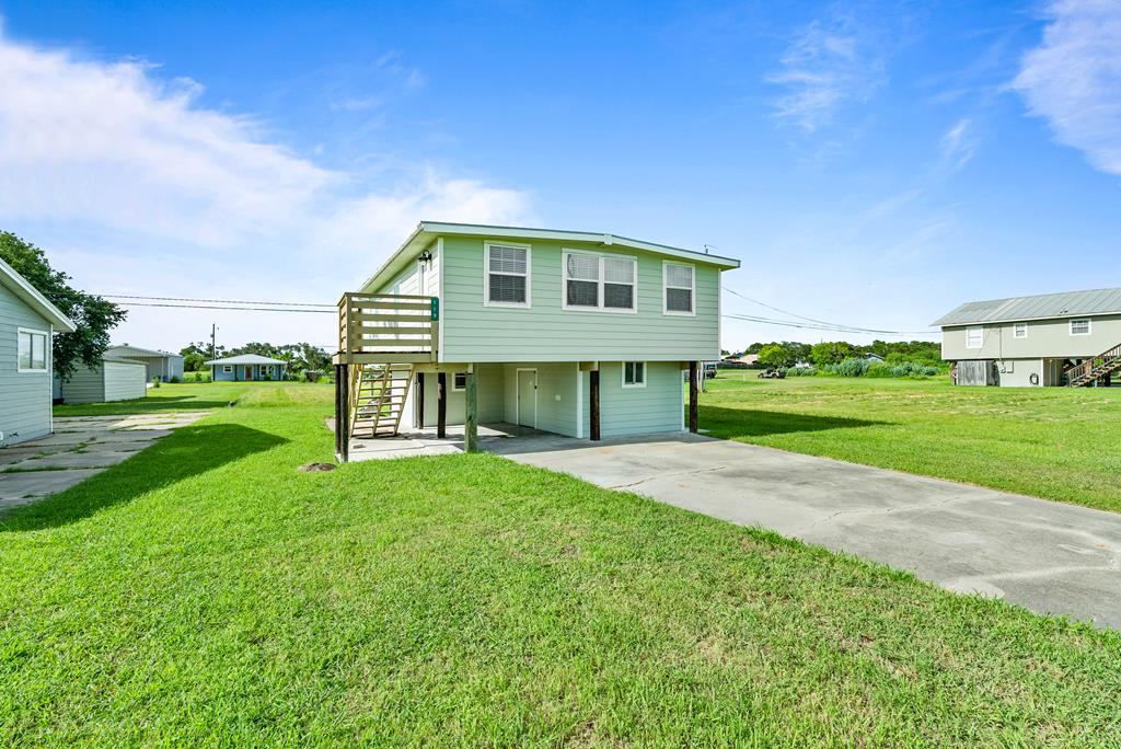 Discover the perfect coastal escape in this charming 850 square-foot cottage in the quiet and private Holiday Beach community. Ideal as a weekend getaway or an income-producing rental, this inviting home features a nice back deck with scenic views—perfect for morning coffee or evening sunsets. The cozy interior offers an open concept with living kitchen and eating space with 2 bedrooms and one bathroom creating a truly comfortable retreat, while the downstairs area includes a multi-use space, storage and workshop—ideal for hobbies or storing your toys. Enjoy exceptional access to some of the best fishing in the area with 2 community boat launches, a private pier extending into Copano Bay, and a sparkling community pool just steps away. Coastal living doesn't get more convenient or relaxing than this.
