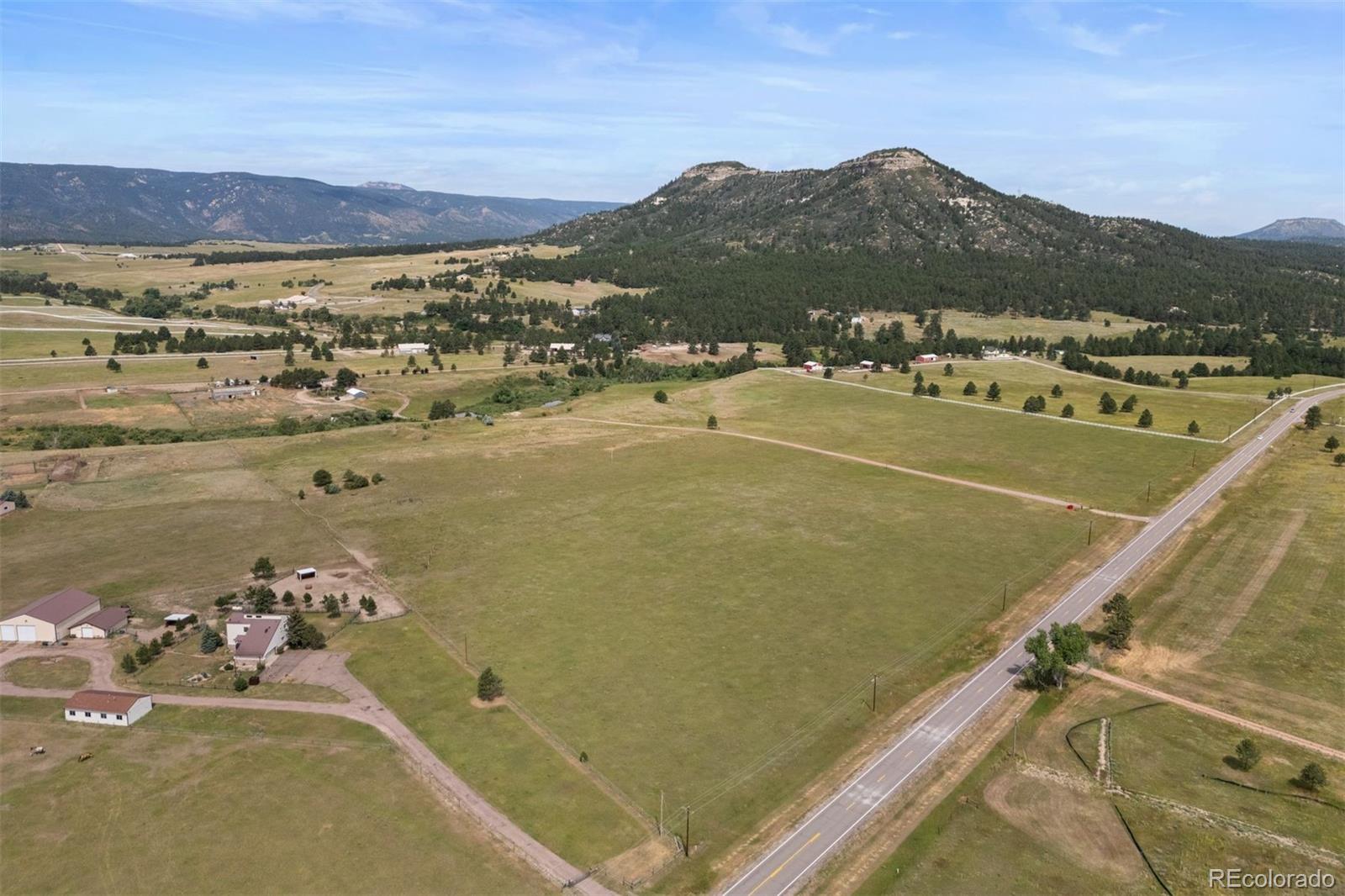 Just minutes from the charming town of Larkspur, this 58-acre property offers a striking mix of natural beauty and versatility. Rolling, lush pastures stretch out beneath big Colorado skies, framed by mature trees and views of buttes and vistas, including a clear line to Pikes Peak. Gentle canyons add character to the terrain, and a year-round pond and seasonal stream complete the landscape. The property is fully fenced, with a modular home, detached three-car insulated garage with a finished workshop area with heat and electric, and an original homestead barn from the 1930s. Two wells and water rights are already in place. Comprised of three separate parcels, the land offers flexibility to create a multi-generational retreat where everyone has room to breathe. The location offers convenient access to both Castle Rock and Colorado Springs, with the town of Larkspur—and its everyday amenities, shopping, and dining—just a short drive away. Whether you’re dreaming of a working ranch, a legacy homestead, or a place where generations can gather, this land is ready.