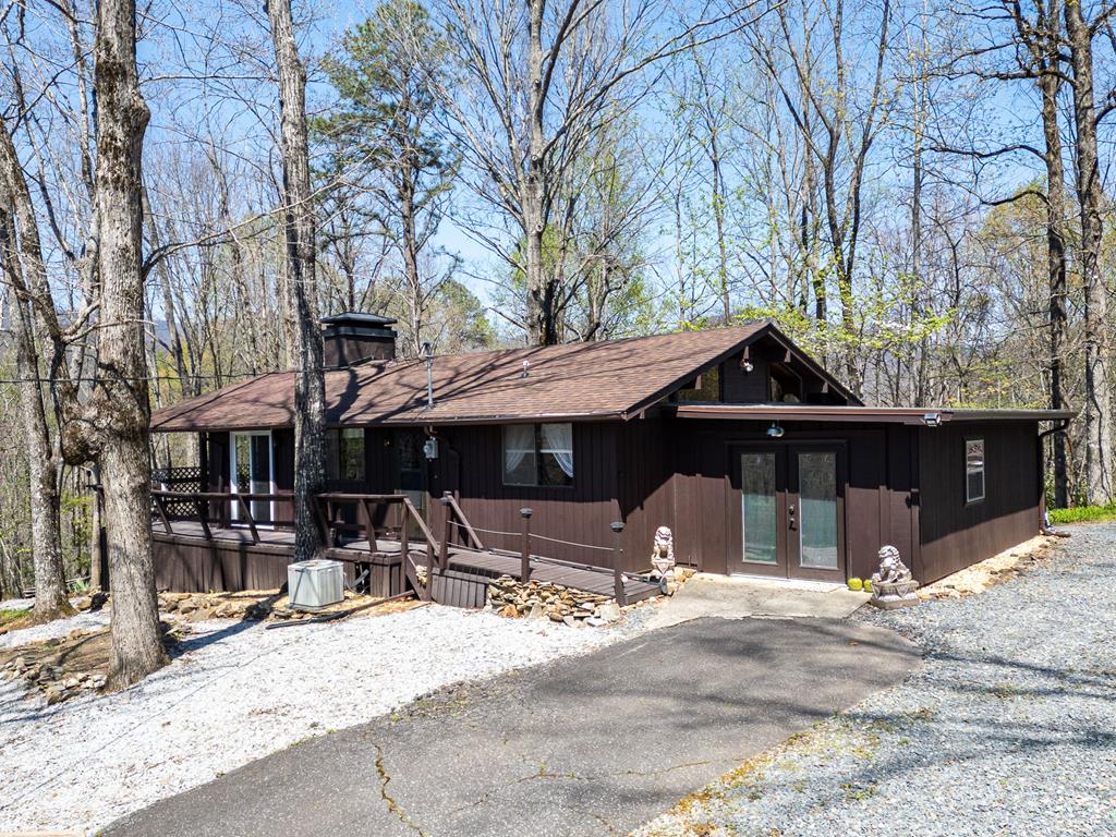 Charming and well-maintained 2BR/2BA mountain cabin with bonus room with a blend of character, comfort, and value.   Inside, you'll find vaulted ceilings, warm wood walls, and abundant windows that create a bright, cozy atmosphere throughout.    Fresh, clean, and lovingly cared for, this home is truly move-in ready and priced to sell at just $225,000.    Enjoy mountain living from the large covered porch, the perfect spot for morning coffee, relaxing evenings, or entertaining guests.   The property also features a circular driveway, oversized 2-car carport, large outbuilding, raised garden beds, and a welcoming firepit and picnic area, creating multiple spaces to enjoy the outdoors.     Enjoy the peaceful surroundings, and mountain view all within close proximity to popular whitewater rafting and outdoor recreation.   Perfect as a mountain getaway, vacation rental, or comfortable full-time residence, this property offers flexibility, charm, and affordability in the gated community of Granny Squirrel.   Visit today, it will not disappoint.