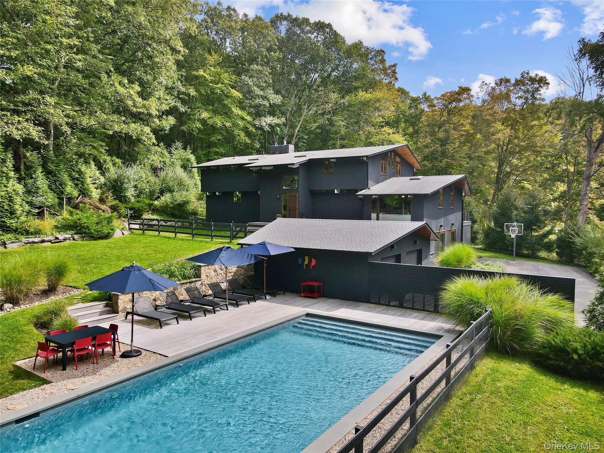 Perfectly turn-key modern stunner available in time to enjoy the pool this summer! Completely reimagined and renovated. Every detail is impeccable. Sunlight streams in from floor-to-ceiling mahogany windows/doors that open onto the expansive deck. New rift-sawn wide-plank oak floors and meticulously refinished ceilings add warmth and character. Thoughtfully designed throughout. Modern Scandinavian retreat vibes on nearly six acres of privacy, quiet, and natural beauty. The open plan is anchored by a quartz-clad chef’s kitchen with dining area, breakfast nook, and chic den, flowing seamlessly into the stunning living room with its Moroccan-tiled gas fireplace. A tucked-away main-level suite offers flexibility as a restful guest room or private primary, complete with a spa-like bath. Upstairs, two thoughtfully designed bedrooms share a bath, while the primary suite impresses with a custom designer closet and an oversized bathroom featuring a freestanding tub, dual-head shower, and double sinks. The entry level with heated polished poured concrete floors is comprised of a living room space, yoga/gym/meditation room with infrared sauna, full bath, and large laundry room. Just outside the door is the brand-new garage designed for two cars and ample storage. Beyond that is the newly built pool perfectly situated for sunlight from morning to night. The striking property is bordered by wildflower gardens, mature trees, stone walls, and graceful lawns.In addition to all of that, 21 Black Spring offers enviable convenience — zoned for the award-winning Katonah-Lewisboro schools and only minutes to Bedford’s chic shops, coffee spots, restaurants, and the newly refurbished Bedford Playhouse that shows first run and revival movies. The celebrated Bedford Post Inn is just two and a half minutes away, and the vibrant village of Katonah, known for its lively downtown and cultural scene, is only a short drive. Direct access to Bedford Riding Lane trails and Ward Pound Ridge hikes round out this ideal location.A rare blend of modern design, natural serenity, and prime location, less than an hour from NYC, 21 Black Spring is a home that truly has it all.House is in the Town of Bedford with a mailing address of Pound Ridge. Use Pound Ridge for GPS.