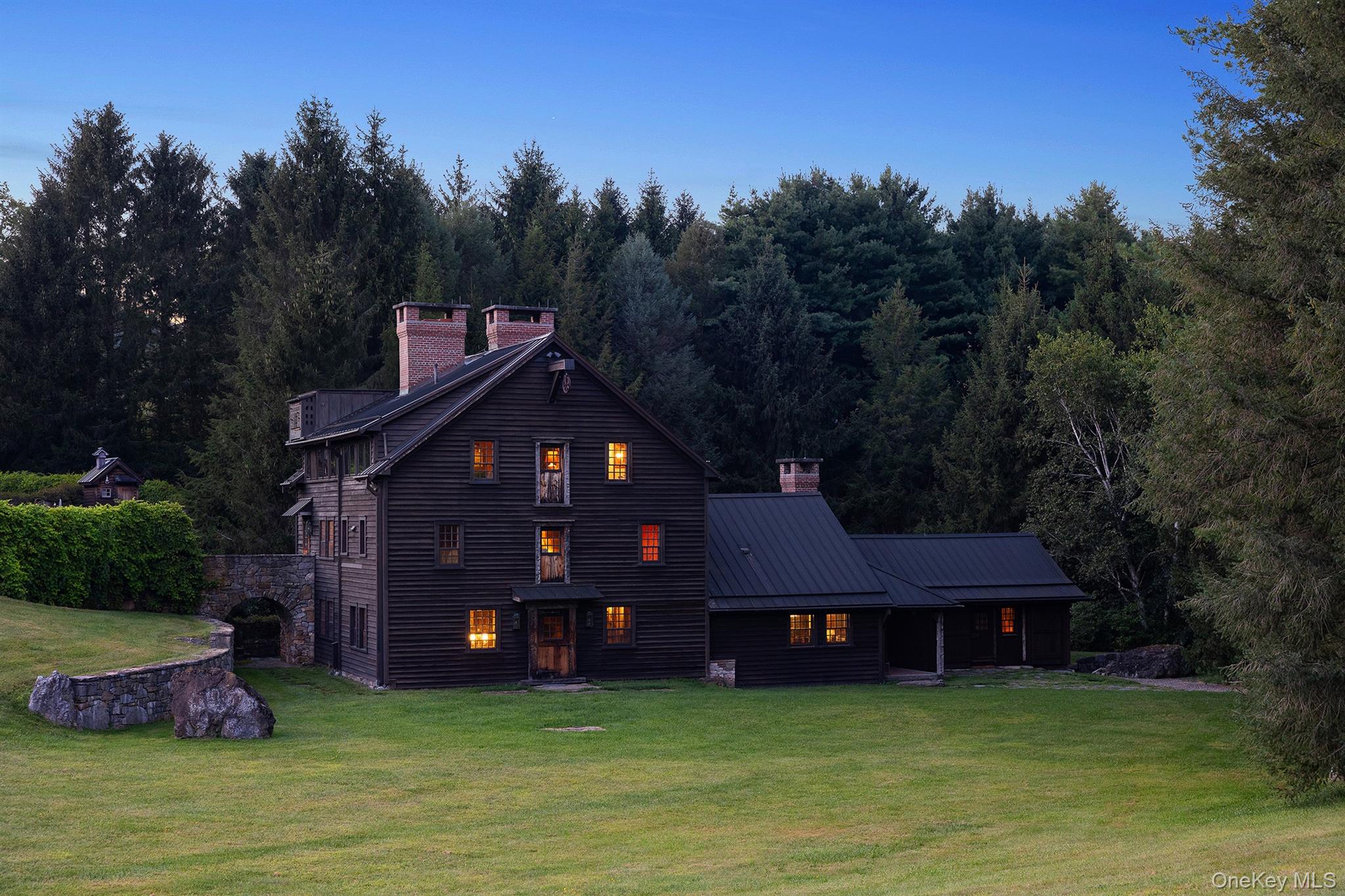 For the first time in history, Mill Farm — Spanning more than 2,000 contiguous acres in Ancramdale, New York, — is being offered to the market. Almost all of the farm is surrounded by thousands of acres of adjacent protected conservation land, making it the only 2,000-acre working farm in the region, ensuring a level of privacy and ecological integrity that cannot be duplicated. Steeped in history, The Mill House dates back to the Revolutionary War era and the Livingston family, and is the conversion of the famed Grist Mill “Defiance,” a rare surviving landmark of early American industry that established the region’s first foundation of commerce.  At its core is the Mill House, an approximately 5,600-square-foot architectural treasure set directly on the Punch Brook Stream, where the water flows through the home itself to power its historic hydro turbine mill system. There is a waterfall set close to the Mill House that is an ever present living feature of the environs, as it is closely visible from nearly every room. Adjacent, the former Mill Keeper’s House has been reimagined as a private movie theatre, blending centuries-old character with modern indulgence. Crest Lane, an approximately 3,500-square-foot masterpiece, stands as a second architectural jewel, featuring a windowed living room with sweeping views across the valley. Beyond these primary residences, the property includes 8 single-family homes, including four newly renovated cottages, each on its own deeded parcel, offering unmatched flexibility for family, guests, or future investment. The two main residences, the Mill House and Crest Lane, are connected by a three-mile internal gravel road system. The land itself is a defining asset. This is arguably the largest working farm within two hours of New York City, with organic-certified hay production, fertile valley floors, and rising elevations to both the east and west that frame extraordinary views. Rare 18th-century barns, including a remarkable Dutch Barn, stand as enduring testaments to America’s agrarian history. An active windmill system still feeds water to various points across the farm, while aquifers and tributaries ensure abundant water availability. Recreational and ecological value are equally profound. The farm contains more than 18 miles of perfected, drivable trails that interconnect every corner of the property, creating a network for horse riding, exploration, and access to resources. Three miles of the untouched Punch Brook, a designated New York State trout stream, run through the property—a pristine waterway under private stewardship. The farm is also home to documented bobcat habitats and study areas in partnership with Panthera.org. Its eastern boundary adjoins a vast conservation bird sanctuary, ensuring uninterrupted natural surroundings and extending the feeling of total seclusion for thousands of acres in every direction. Mill Farm uniquely combines agricultural productivity, historical resonance, and ecological significance. With its unmatched scale, legacy, and proximity to New York City, it represents an opportunity that exists nowhere else in the Northeast — a living landmark, never before available on the open market.