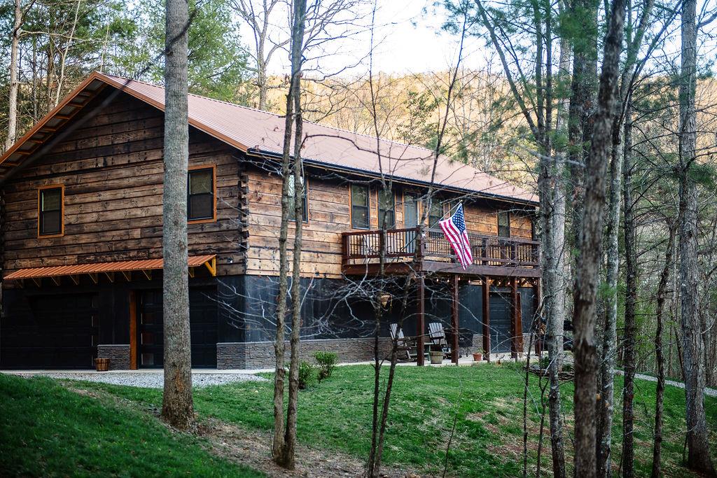 Welcome to your private mountain retreat in the gated community of New River Oaks, where craftsmanship, luxury, and nature come together in perfect harmony. This one-owner, 100% custom-built cabin is truly a rare find and an absolute must-see to fully appreciate the level of detail and quality throughout. From the striking Shou Sugi Ban exterior finish to the convenience of keyless entry, every inch of this home has been thoughtfully designed. Step inside to soaring 16-foot vaulted ceilings, rich cedar trim, and a bright, open-concept layout that blends rustic charm with modern sophistication. The heart of the home features granite countertops, stainless steel appliances, and a seamless flow ideal for both everyday living and entertaining. Comfort and efficiency are top-tier with a 19 SEER heat pump and a new propane furnace, while wide 36-inch doorways add both accessibility and style. The main-level owner's suite is nothing short of exceptional, offering a spa-like bath complete with a rain shower, while the guest bathroom showcases a timeless clawfoot tub. A dedicated office space, separate laundry room, and generous storage round out the interior. Outdoor living is just as impressive, with two expansive 8' x 24' decks perfect for relaxing or entertaining while overlooking your 1.8-acre slice of paradise—complete with a creek, stocked pond, and ultimate privacy. Additional highlights include three garage doors, concrete sidewalks, stone foundation accents, and a 10-year warranty on most appliances for added peace of mind. As a resident of New River Oaks, you'll also enjoy access to community common areas and the tranquility of a secluded, gated setting. This home is more than just a property—it's a lifestyle. Schedule your private showing today and experience this one-of-a-kind luxury cabin for yourself.