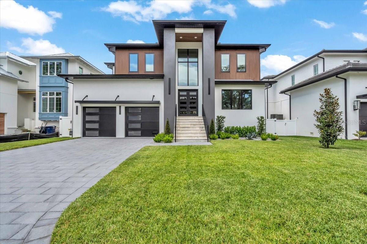 This newly completed 5,000+ sq ft Sunset Park home by Gloger Construction offers luxury and peace of mind with premium builder upgrades including a whole-home 22kW GENERAC GENERATOR, GARAGE CAR LIFT, and FLOOD INSURANCE PREMIUM COVERED FOR 1 YEAR. Designed above FEMA standards with DOUBLE BLOCK construction and hurricane-impact windows, it features 5 bedrooms, 4 full baths, 2 half baths, a dedicated office, and a spacious upstairs bonus room. The open-concept living area includes a TEMPERATURE CONTROLLED WALK IN WINE ROOM, and a gas fireplace, flowing seamlessly to a balcony and outdoor kitchen overlooking the pool and spa. The chef’s kitchen boasts Thermador appliances, quartz counters, and a hidden butler’s pantry. A first-floor primary suite offers a spa-like bath, walk-in closet, and balcony access—all just minutes from top-rated schools and local dining.