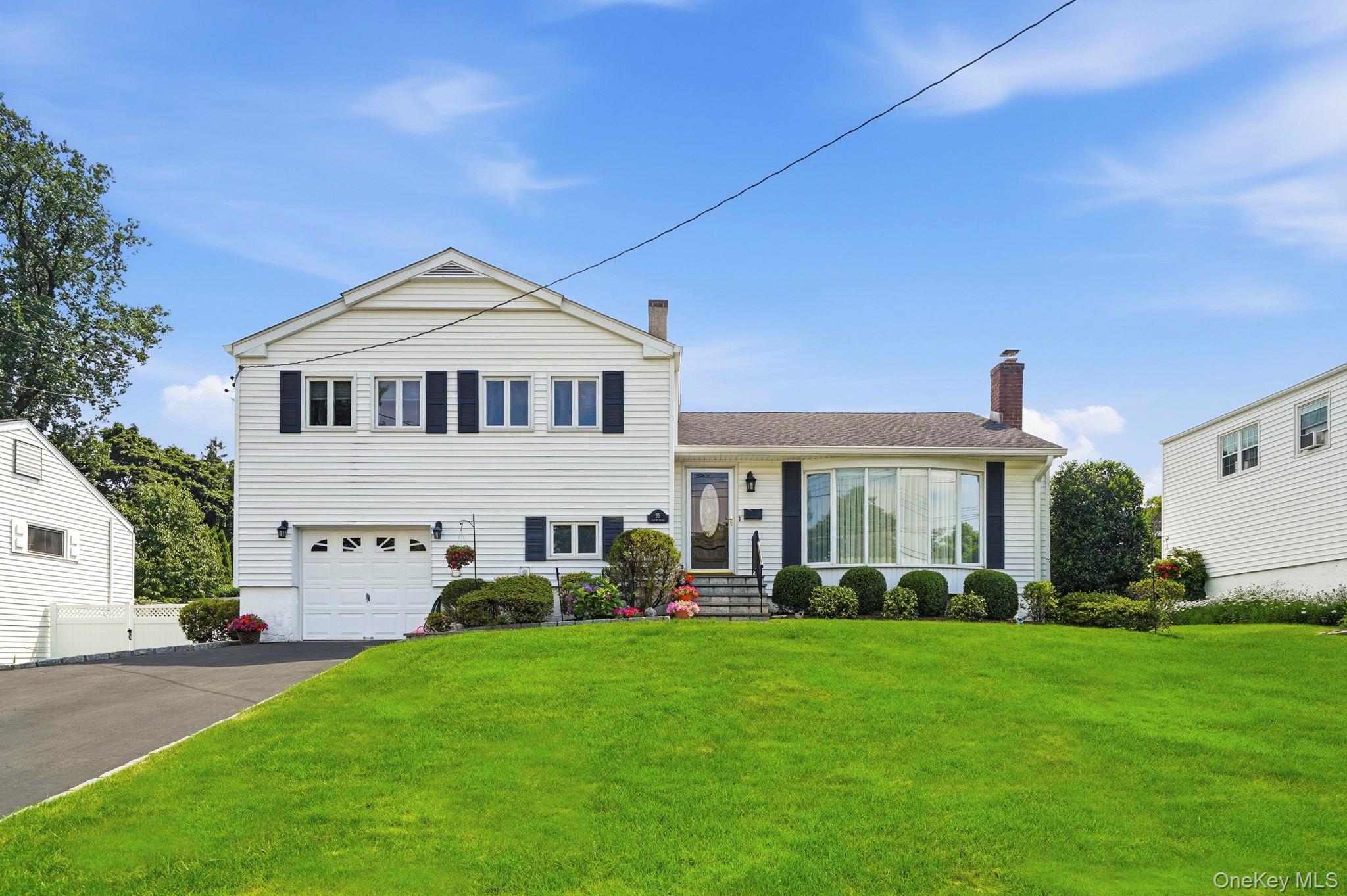 In the sought after Ardsley School District, this lovingly maintained Split-Level home, offers access to Anthony Veteran Park including pools, pickleball and tennis, and Greenburgh Recreation.. Designed for today's lifestyle, this move-in ready home combines comfortable living spaces with fantastic indoor-outdoor flow.  The sun-filled main level features an open-concept living room, dining room, and eat-in kitchen with sliders leading to a spacious deck overlooking the beautifully landscaped, level backyard. Just steps away, an interlocking stone patio creates the perfect setting for outdoor dining, playtime, entertaining, or simply relaxing. A sprinkler system helps keep the grounds looking their best all season long.  The lower level offers exceptional flexibility with a large recreation room featuring sliders to the patio, a generously sized fourth bedroom that's ideal for guests, a home office, or playroom, plus a powder room, laundry, utility room, and additional storage. Please note the house is heated with gas so it is possible to switch out the electric range for a gas range.Everyday life is made easy with free bus service for elementary and middle school students, while Ardsley High School is within a short distance. Enjoy nearby parks, playgrounds, shopping, restaurants, and convenient public bus service to the Hartsdale Metro-North station, with permit parking available through the Town of Greenburgh.  Whether you're looking for room to grow, space to work from home, or a yard where everyone can enjoy the outdoors, this beautifully cared-for four-bedroom home offers an incredible opportunity in one of Westchester's most sought-after school districts. 35 minute train from Hartsdale station to Grand Central Station.