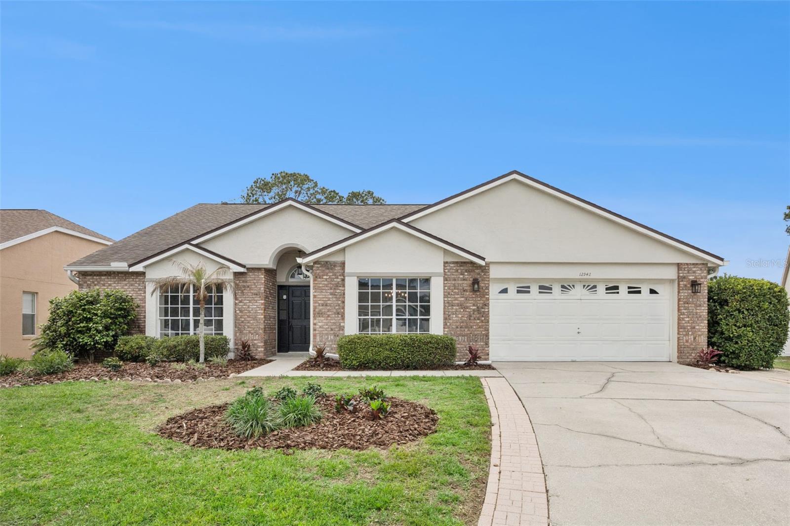 Welcome to this beautifully updated pool home located in the highly desirable Woodlands section of Waterford Lakes! ROOF 2020, WATER HEATER 2024, AC 2023. Offering 4 bedrooms, 3 full bathrooms, and 2,526 square feet of thoughtfully designed living space, this one-story residence stands out with its exceptional layout, abundant natural light, and oversized backyard. From the moment you arrive, the charming brick front elevation sets the tone for what’s inside. Step through the front door to find soaring vaulted ceilings and multiple skylights that flood the home with natural light, creating a bright and inviting atmosphere. The front of the home features separate formal living and dining rooms, offering flexible space for entertaining or everyday living. The updated kitchen is both stylish and functional, showcasing painted cabinetry with modern hardware, granite countertops, and stainless steel appliances. It opens seamlessly into the spacious great room, where French doors lead to an expansive covered pool deck—perfect for outdoor dining, lounging, and entertaining. Step outside to your private backyard retreat, featuring a fully screened-in pool that is larger than most, along with an oversized yard that offers plenty of space to enjoy. The backyard is fully fenced with white vinyl fencing along the rear and includes a large storage shed for added convenience. One of the most unique and desirable features of this home is its dual primary suite layout. The main primary suite is generously sized with vaulted ceilings, a large walk-in closet, and a beautifully updated en-suite bathroom complete with a garden tub, glass-enclosed shower, dual vanities, and updated fixtures. On the opposite side of the home, a second suite offers its own walk-in closet and full bathroom, ideal for guests, multi-generational living, or use as a private in-law suite—with direct access that also functions perfectly as a pool bath. Two additional bedrooms are located in a separate wing with a third full bathroom, providing privacy and flexibility for family or guests. Extensive upgrades throughout the home include luxury vinyl flooring, a decorative tile foyer, fresh interior paint, updated baseboards, modern lighting fixtures, ceiling fans, and fully renovated bathroom features including faucets, mirrors, and lighting. Ideally located just minutes from top-rated schools, shopping, dining, and entertainment, including Waterford Lakes Town Center, this home offers the perfect combination of space, style, and convenience. This is a rare opportunity to own a spacious, move-in-ready pool home with a truly versatile layout—schedule your private showing today!