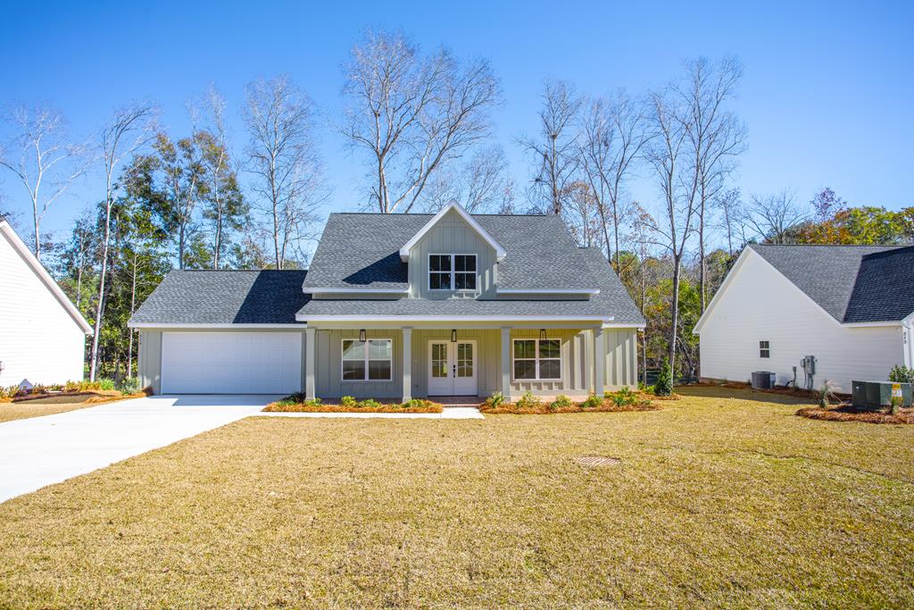 Thoughtfully designed and filled with natural light, this 3-bedroom, 2-bath home offers 2,533 square feet under roof with a well-divided split floor plan and an impressive open-concept layout. The entry opens into a wide living, dining, and kitchen area with soaring high ceilings and abundant natural light.    The kitchen is ideal for those who love to cook, featuring white Pelican countertops, granite countertops, soft-close cabinetry, generous cabinet storage, and a spacious walk-in pantry. Throughout the home, all fixtures were handpicked by an interior designer, creating a refined, cohesive aesthetic.    The primary suite serves as a private retreat with high tray ceilings, a double-sink vanity, a luxurious shower, and a roomy walk-in closet. Both the primary bedroom and kitchen enjoy peaceful views of the preserved natural setting behind the home, creating a serene and private atmosphere.    Outdoor living is enhanced by a charming front porch with herringbone brick pavers, a covered rear porch, and an additional patio space—perfect for relaxing or entertaining. Located in Bloomfield Lakes, a growing community ideal for afternoon strolls and quiet moments, this home invites you to enjoy coffee on the back patio while taking in the surrounding nature.    Seller is a licensed real estate broker (License #340473).