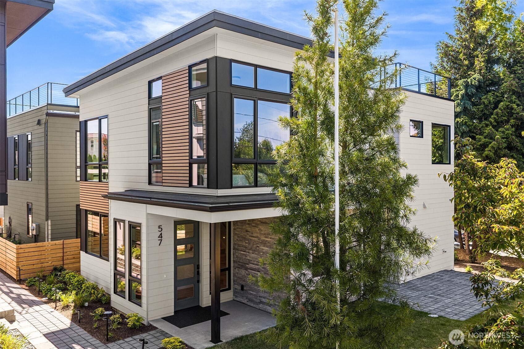 BriKat Homes presents Reserve on 6th, a boutique new home community ideally sited in Kirkland's West of Market neighborhood. Sweet covered porch with timeless stone facade leads to foyer with thoughtful built-ins. Comfortable for both hosting and daily life, the open living & dining area includes gas fireplace, built-in speakers & floor-to-ceiling windows for an airy feel. In the stunning chef's kitchen enjoy Calacatta slab countertops & backsplash with a dramatic waterfall edge, locally-built Abodian cabinets extending to the ceiling, Bertazzoni appliances with gas cooking, Kohler fixtures & water filtration system. Head outside to the front patio & spacious yard to enjoy summer barbecues with ample room for play set. The main floor den is a perfect flex space, ideal as a home office or quiet retreat. Upstairs, filled with natural light, the primary suite features a 5-piece bath with heated floors, free-standing matte black tub & built-in speakers. Two additional generously-sized bedrooms, a full bath with heated floors, large laundry room with counter space & sink, plus linen storage. Other highlights include smart home wiring, 5-panel doors & an ERV system for fresh air year-round. Perched above the neighbors, find your expansive rooftop deck with sweeping western views of Lake Washington & the Space Needle. West of Market offers top-rated schools, easy freeway access & a quiet suburban ambiance close to dining, boutiques & Waverly Beach Park.