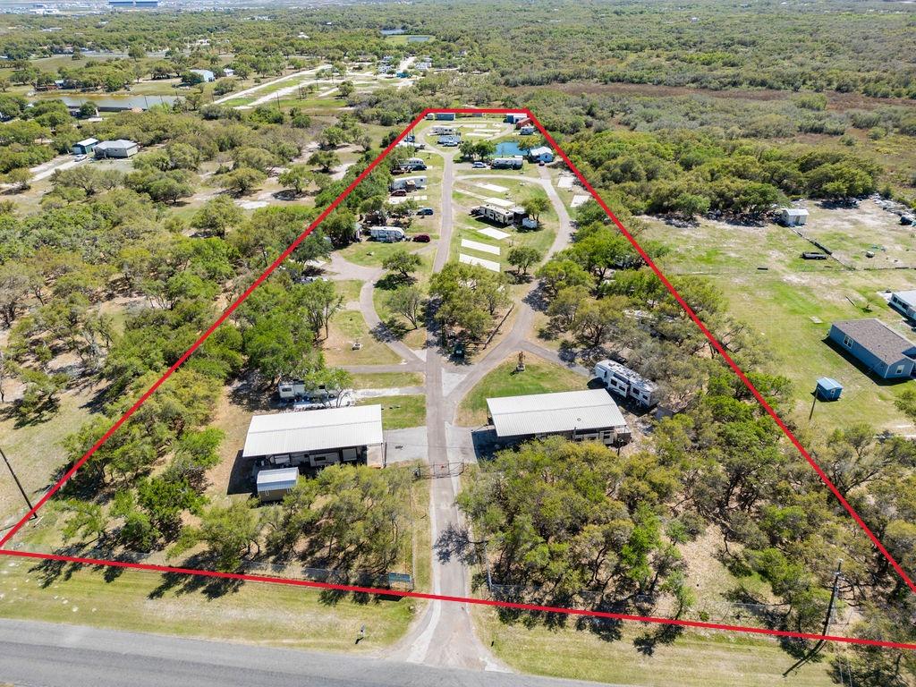 Great investment opportunity in a prime Rockport location on Corpus Christi Road off HWY 35 Bypass! This established RV park features 39 RV slots, including 2 covered spaces, plus 2 income-generating potential cottages and a huge slab for a mobile home. The property includes a laundry shed for tenant convenience, a workshop/garage building—ideal for equipment storage, business operations, or additional parking—and a fenced dog park area your tenants will love. Fully fenced and gated for privacy and security. Currently home to long-term tenants to provide consistent monthly income, and vacancies offering the potential to increase revenue through short-term rentals. There's also room to expand or reconfigure for even greater return on investment. Whether you're looking to grow your portfolio or start fresh in the Rockport market, this property offers good income potential, infrastructure in place, and multiple avenues for future development. Don't miss out on this rare opportunity with endless potential!