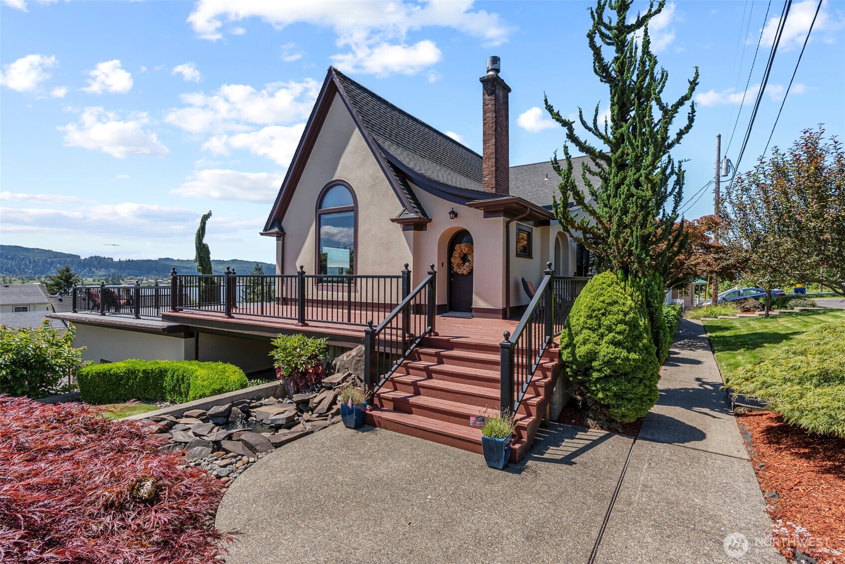 Welcome to Cathlamet, perched on the banks of the Columbia River. Just two blocks above downtown, this beautifully maintained 1928 Tudor sits on a rare double corner lot with sweeping views of the river and Puget Island. Once the site of Queen Sally’s Well on the Lewis & Clark Trail, the home blends historic charm with modern comfort—featuring mahogany paneling, large view windows, a bright kitchen, cozy attic retreat, and flexible bonus spaces. A private office with separate entry adds versatility. Enjoy the expansive deck, lush landscaping, hot tub, fenced yard, and oversized garage with workshop. Minutes from golf, the marina, and galleries. Ideal option for multigenerational living or Airbnb. Walk to Main Street and the Elochoman Marina