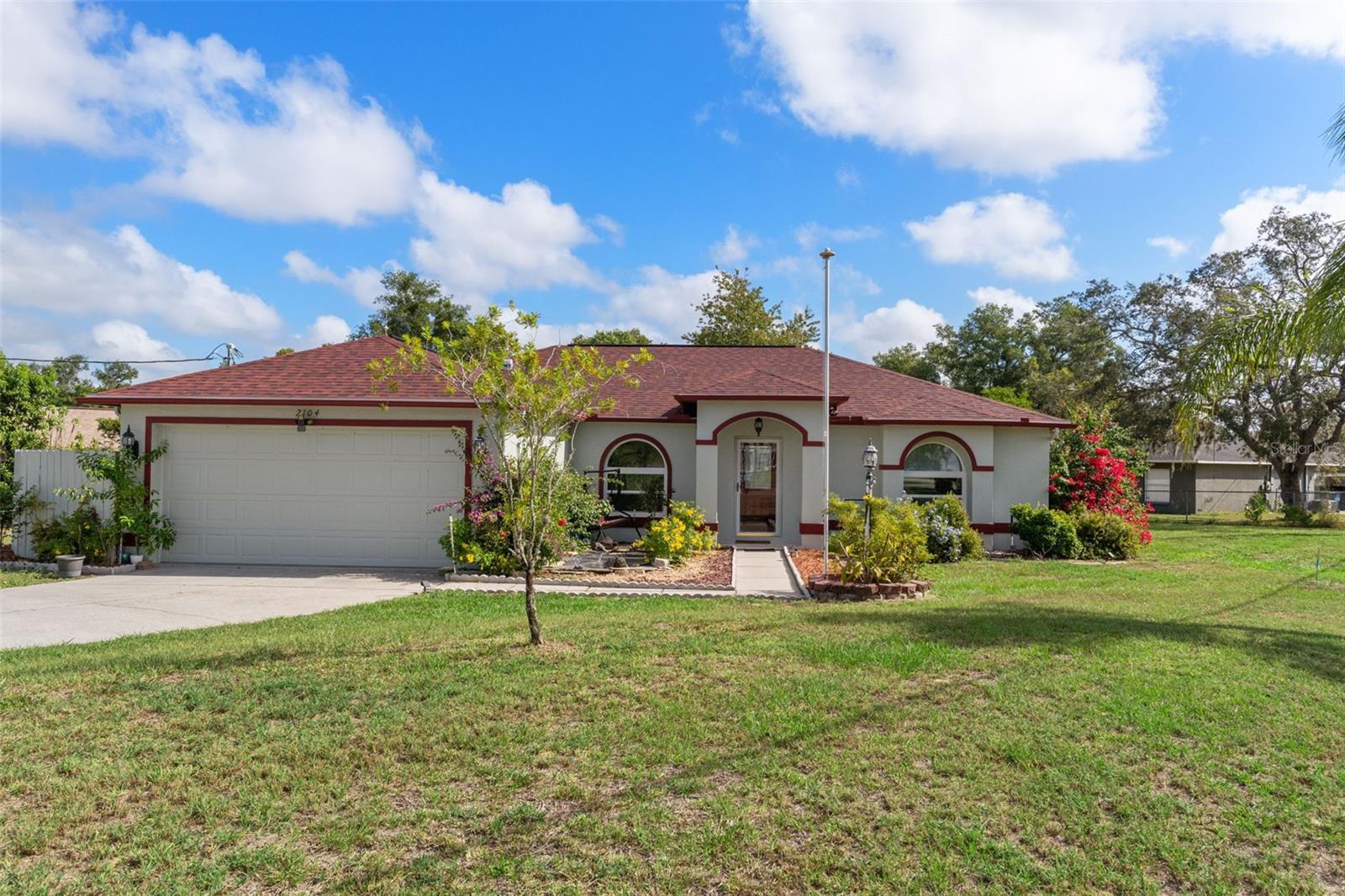 Impeccably maintained 3-bedroom 2-bath home on a spacious corner lot with shaded backyard and deck. Roof replaced 3 months ago; exterior painted 4 months ago. Most windows upgraded to double-pane. Four-season tiled Florida room features sliding double-pane windows and dedicated A/C unit. Granite countertops in kitchen with eat-in area, custom lighting, and motion-activated faucets. Greatroom-style open floorplan with high ceilings and knockdown textured walls/ceilings. Lifeproof LVP and tile flooring throughout. Large guest bedrooms. Inside laundry with comfort-height washer & dryer (2017). Drain field replaced within the last 2 years. Detached 10x12 utility shed included. 2-car garage with hurricane-rated door, pull-down attic access, workbenches, and shelving. Energy-efficient and convenience features throughout make this home truly move-in ready!