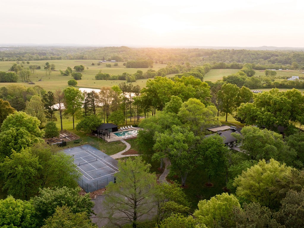 Welcome to True South Farm, a rare 17-acre agritourism estate with established income and lifestyle appeal. Set among the rolling Tennessee hills with panoramic views of surrounding farms and ponds, this exceptional property offers not only the Tennessee dream hobby farm residence but a turnkey opportunity. True South Farm has a nationally recognized brand, income-producing assets, a registered Highland cow operation, resort-quality , and a reputation built among some of Nashville's most celebrated artists and songwriters — everything is already here, already working, already earning. The fully restored 7,000 sq ft hilltop manor home, originally built in 1966, features 7 bedrooms, a chef’s kitchen, a spacious great room anchored by a stunning stone fireplace, bunk room, and full gym, all surrounded by mature hardwoods, curated landscaping, and resort-style amenities. Additional accommodations include a 1,700 sq ft barn residence equipped with 2 bedrooms, 2 baths, a spacious kitchen and living room space and panoramic views, as well as a 900 sq ft pool house, bringing total sleeping capacity to approximately 30 guests. Designed for both personal enjoyment and investment use, the property includes a pool and pool house, tennis/sports court, garden, firepits, multiple event spaces, and established infrastructure for weddings, retreats, and gatherings. A profitable, income-producing farm with a registered Highland cow operation, successful Airbnb history, and nationally recognized brand, True South Farm presents a unique opportunity to step into a fully realized business, private estate, or legacy property in the heart of Middle Tennessee.
