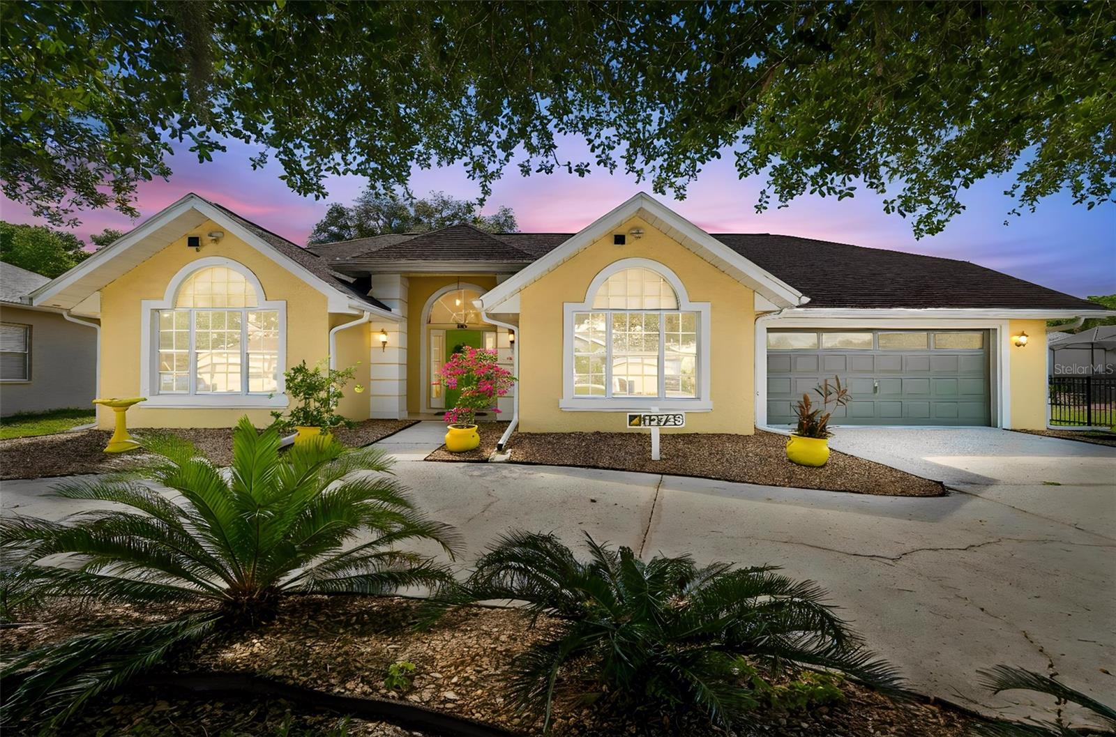 Bright and cheery single-story home located in a gated community in Pasco county is ready to show off! Located in the heart of all that is upcoming in Pasco county, this home is in the perfect location for restaurants, upscale shopping, medical, and entertainment. A-rated schools, including a classical prep school INSIDE the community is a BONUS! Just minutes from the Moffitt Cancer & Research Village. Easy interstate access for easy travel to downtown Tampa or even Orlando! Situated on 0.28 acres, this spacious 3 bedroom, 2 full bathroom residence has NO CARPET. Luxury vinyl flooring and tile throughout making is easy to clean and durable. Open floor plan. Stunning landscaping just welcomes you inside where you have vaulted ceilings and private views. Cozy living room opens up to the designated dining room that flows easily to the kitchen. Stainless steel appliances, large pantry, under cabinet lighting, and wood cabinets. Batwing island provides additional seating. Cafe area perfect for enjoying coffee and breakfast. Off of the kitchen tucked away is the expansive primary retreat with private views, tall ceilings and its own sliding doors to the patio. Ensuite with dual sinks, garden tub and tiles walk-in shower. On the other side of the home you have 2 separate bedrooms that share a FUL bathroom. This home offers something special, an additional vented patio/living space that can be closed up or opened up at anytime during the year. Take your entertaining into this space which is both relaxing and bright with views of trees. Circular driveway is classy. Full of potential yet ready to move into, 12728 Flamingo Parkway is ready to be enjoyed for many years to come.
