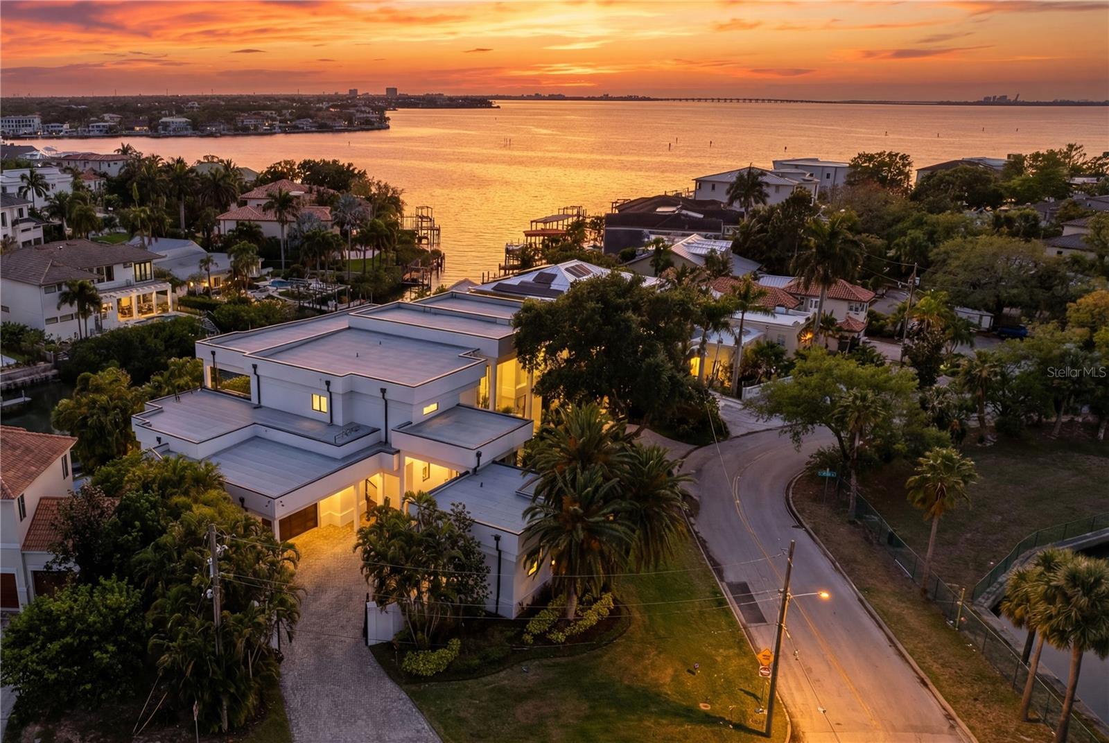 Welcome to this rare, gated waterfront estate situated on a double lot in the coveted Beach Park neighborhood. This all block, architectural wonder built by Alvarez Homes offers timeless elegance and modern luxury across 9,000 square feet of meticulously designed living space. Revealing an impressive layout that features six bedrooms and eight bathrooms, this residence also showcases a separate detached guesthouse and full bath that provides additional sleeping quarters and income potential. From the moment you enter the grand foyer, you are greeted by a breathtaking indoor floor to ceiling waterfall and graceful winding staircase, setting a serene tone that continues throughout the home. Designed for both entertaining company and everyday comfort, this residence includes soaring ceilings, an expansive living and dining area, and a light and bright kitchen with quartz counters, Sub Zero appliances and windows facing west that overlook the water. There is an enormous kitchen island with storage on either side that is perfect for serving family and guests. The walk-in pantry works like a back kitchen offering an extra refrigerator, microwave, and ample shelving providing additional food storage. A temperature-controlled glass wine cellar is perfect for the wine enthusiast.  Showing off its impressive floor plan, this home boasts three unbelievably large owner’s suites with attached en-suite bathrooms. Two of the owner’s suites are located on the first floor, on either side of the home, providing full privacy. The third owner’s suite is on the second level offering unparalleled flexibility for multigenerational living or hosting company in style. Three additional bedrooms and two attached baths are located upstairs and can be easily accessible using the home’s elevator. Back on the main floor, there is a separate office with French doors and built-in cabinets, as well as a flex room with pilates flooring for the ultimate home gym, yoga studio or playroom. A large living room slider provides easy access to the outdoor kitchen with a gas grill, pizza oven, flat top cooker, refrigerators and beer tap where your guests can lounge and relax by the pool and spa. The attached dock and covered slip provide ample room for your boat with open access to the bay and gulf, perfect for embracing Tampa’s waterfront lifestyle.  The exterior is equally impressive, featuring mature landscaping enhanced by elegant lighting, a low-maintenance turfed backyard, and a stately circular paved driveway behind a secure double gated entry. The west-facing frontage captures spectacular sunset views, bathing the home in warm, golden light each evening. The detached private guesthouse provides additional accommodations for visitors, nanny or staff, while recent upgrades—including new AC units, a new roof, and whole house and lighting automation—offer peace of mind and modern efficiency.  Ideally situated just minutes from Tampa International and a private jet airport, I-275 and the Veterans Expressway, this home offers unmatched convenience to Tampa’s premier hospitals, shopping, dining, Raymond James Stadium, Benchmark Arena, top-rated public and private schools and is only a block away from the grocery store allowing the home to blend luxury living with everyday ease. This is more than a home—it’s a statement of lifestyle, sophistication, and waterfront excellence. Come and see this beautiful property.  It’s ready to welcome you home!