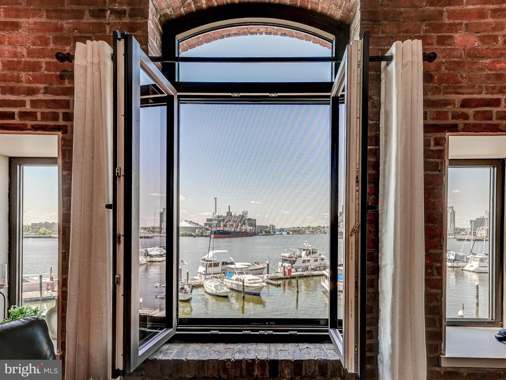 Enjoy true waterfront living at its finest in historic Fell’s Point! Perfectly positioned at the end of a charming cobblestone street, this beautifully appointed one-bedroom, one-bath residence in Henderson’s Wharf offers sweeping, unobstructed views of Baltimore Harbor from the living room, kitchen, and bedroom. This spacious, one-level condominium blends historic character with modern updates, featuring exposed brick walls,  wood flooring, and updated kitchens and baths with granite countertops. The thoughtfully designed layout includes a generously sized bedroom with a walk-in closet, creating both comfort and functionality. With approximately 1,043 square feet, this residence offers a rare opportunity to enjoy serene waterfront views while being just steps from the vibrant energy of Fell’s Point. One assigned garage parking space is conveyed with the unit for added convenience.Residents of Henderson’s Wharf enjoy premium amenities, including 24-hour security and a fitness center. Located within walking distance to top restaurants, shopping, nightlife, and major hospitals, with easy access to I-83 and I-95, this home offers the perfect blend of tranquility and accessibility. Experience the best of waterfront city living in one of Baltimore’s most iconic neighborhoods.