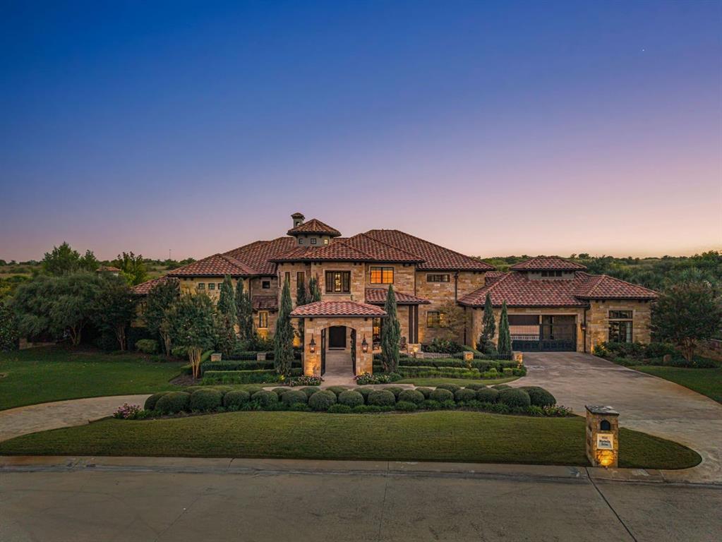 Positioned within the prestigious guard-gated community of Montserrat, 9541 Marbella Drive is a masterfully crafted luxury estate offering an exceptional blend of architectural sophistication and resort-style living. Set on one-acre and spanning 7,426 square feet, this beautiful residence features 5 bedrooms and 5.5 baths, thoughtfully designed for discerning buyers seeking both elevated entertaining and everyday comfort. From the moment you enter, expansive interiors are defined by soaring ceilings, refined finishes, and abundant natural light—creating a seamless flow between indoor and outdoor living spaces. The chef’s kitchen, outfitted with premium appliances and marble, anchors the home and opens effortlessly to the main living and dining areas—ideal for hosting on any scale. Designed to rival private resorts, the home offers a dedicated fitness studio, media room, and an expansive game room with wet bar, delivering an unparalleled lifestyle experience within your own residence. The primary suite is a private sanctuary, featuring a spa-caliber bath, oversized walk-in closet, private courtyard with fireplace, and serene views. Each secondary bedroom is appointed with ensuite baths, offering privacy and comfort for family and guests alike. Outdoors, the estate transforms into a resort-inspired retreat, complete with an infinity-edge pool, outdoor living and dining areas, built-in grilling station, covered patio with retractable screens and fireplace—all framed by lush grounds and privacy. Additional highlights include a three-car garage, smart home integration, temperature controlled wine room, and the security of a 24-hour guarded entrance, making this property ideal for luxury buyers seeking privacy, prestige, and proximity to downtown Fort Worth, Clearfork and several private schools.