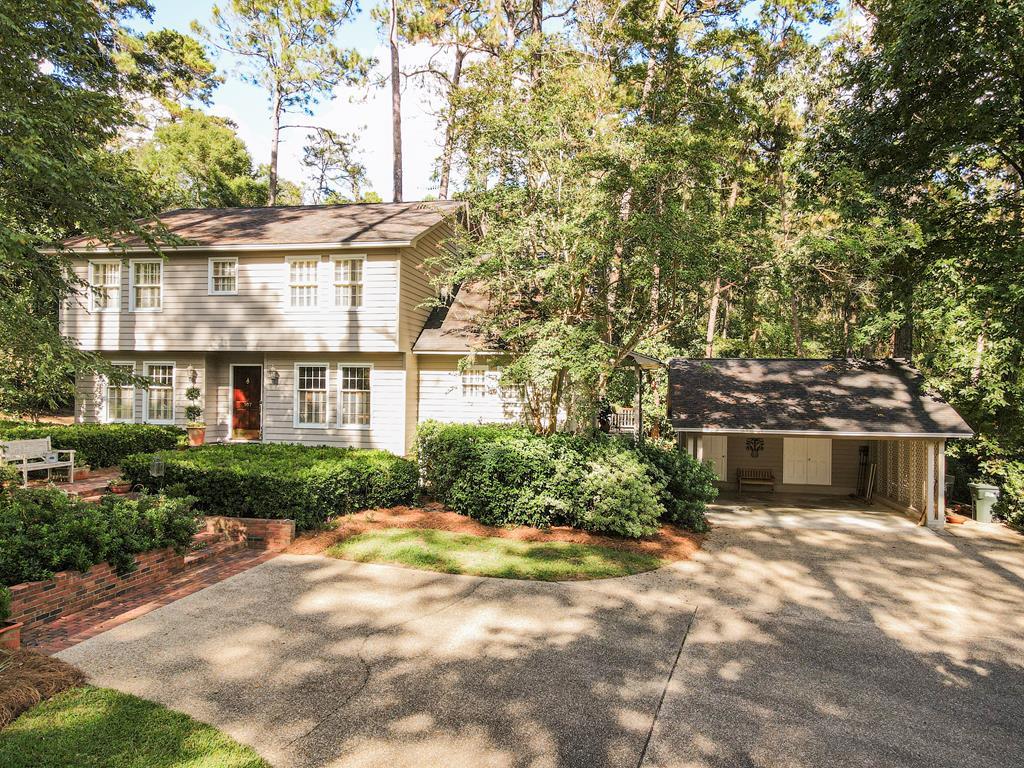 Charming Two-Story Cedar Home on a Private, Landscaped Acre!  This unique, one-owner, traditional-style cedar home offers 2,702 sqft Heated & Cooled and a blend of privacy and convenience. Secluded in a quiet neighborhood, it is moments away from Glen Arven Country Club, Jerger Elementary School, and Downtown Thomasville.  Exterior & Property Highlights  Set on a generous 1.08-acre terraced lot (built 1987). The professionally designed landscape features mature trees, azaleas, camellias, hydrangeas, and crepe myrtles, creating a beautiful, private setting. A long, exposed aggregate driveway with guest parking leads to a detached two-car carport (484 sqft) with attached storage/workshop (176 sqft). A side slip offers space for a small boat/trailer. Enjoy outdoor living with a 420 sqft screened porch and a 250 sqft deck for grilling, both overlooking heavily wooded and private views. Features energy-efficient windows, an architectural shingle roof, and an electric fence for pets.  Interior Details  The home features custom moldings and built-in bookcases. Large windows flood the interior with natural light; most have louvered shutters.  Downstairs: The main floor features an open floor plan with pine and terracotta tile floors. A large family room boasts a wood-burning fireplace. Two offices and a smaller sitting room/study are located off the family room, alongside a large dining room. The cook's kitchen has updated appliances and is open to a breakfast room. A large pantry, storage room with cabinetry, and a half bath complete the downstairs.  Upstairs: Includes all three bedrooms and an extra-large laundry room (potential extra sleeping area). The Master Suite features an en-suite handicap-equipped bathroom and dressing area. The two secondary bedrooms share a Jack and Jill bathroom with separate sink/toilet areas and a shared tub/shower.