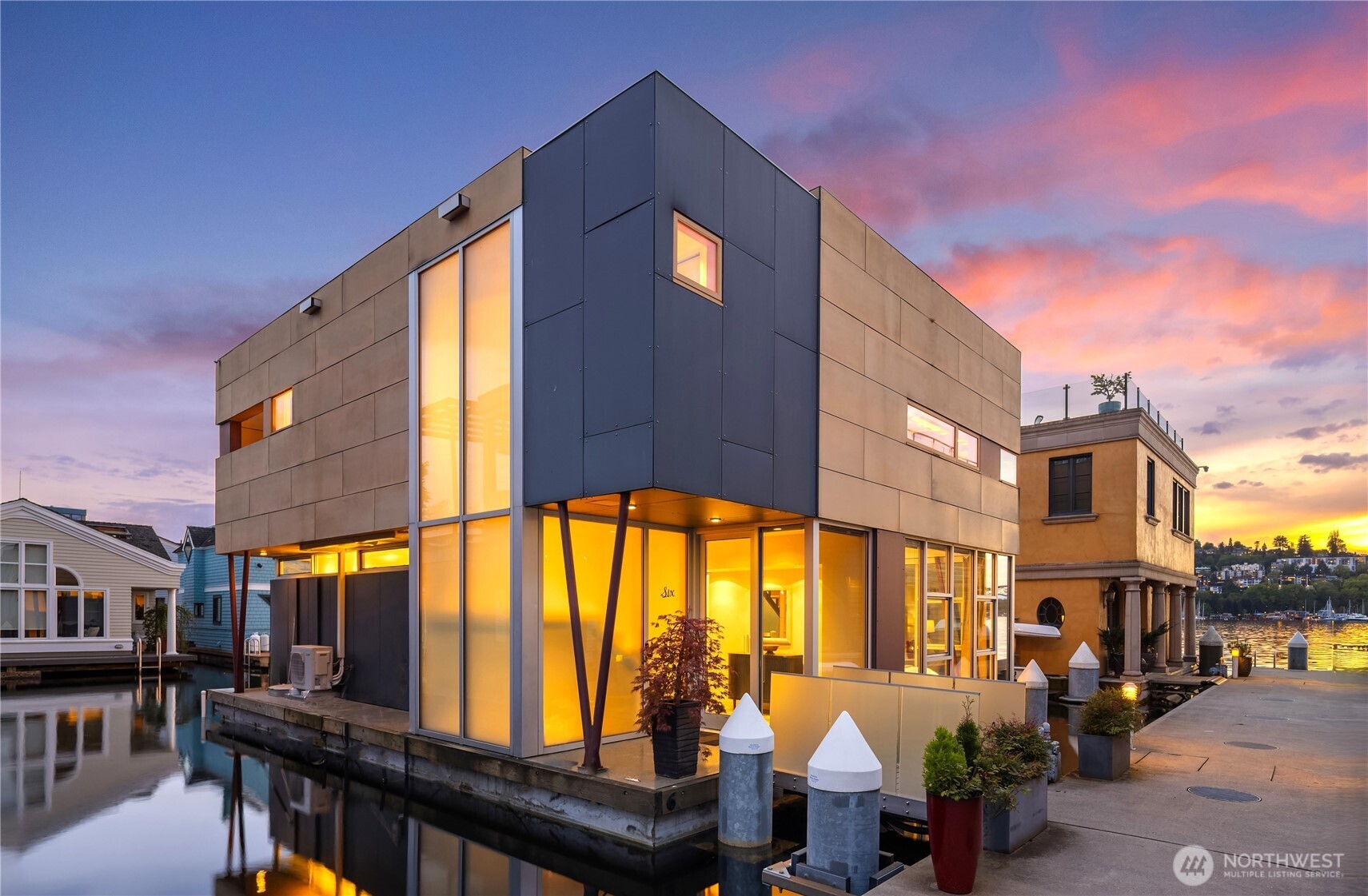 Fairview Landing #6 // Designed by Vandeventer + Carlander Architects, this modern floating home continues Seattle’s rich tradition of life on Lake Union, offering coveted southern exposure and sweeping views of Downtown, Queen Anne Hill, Gas Works Park, the Olympics and Space Needle. Thoughtfully designed, the floorplan inverts a traditional layout by placing public living spaces on the upper level to maximize light, views, and entertaining. Expansive glazing and large sliding doors open to multiple decks, including a rooftop terrace accessed by a sculptural circular stair, creating seamless indoor-outdoor flow. Private spaces are located on the entry level, while a rare underwater lower level with true porthole windows offers an immersive connection to the lake. The home’s carved massing, recessed decks, and material shifts create architectural depth and integrity. Sustainable features include hydronic in-floor heating via energy-efficient heat pump, heat-exchange ventilation, solar power, and strategically placed glazing for passive performance. Exterior fiber cement rainscreen panels and aluminum cladding pair with Alaskan yellow cedar-framed windows, while interiors feature mahogany, zebrawood, bamboo flooring, and warm wood accents, all balancing modern design with livability. Located within the sought after Fairview Landing community with dedicated parking and moorage with remote boat lift, this is refined waterfront living in the heart of the city.
