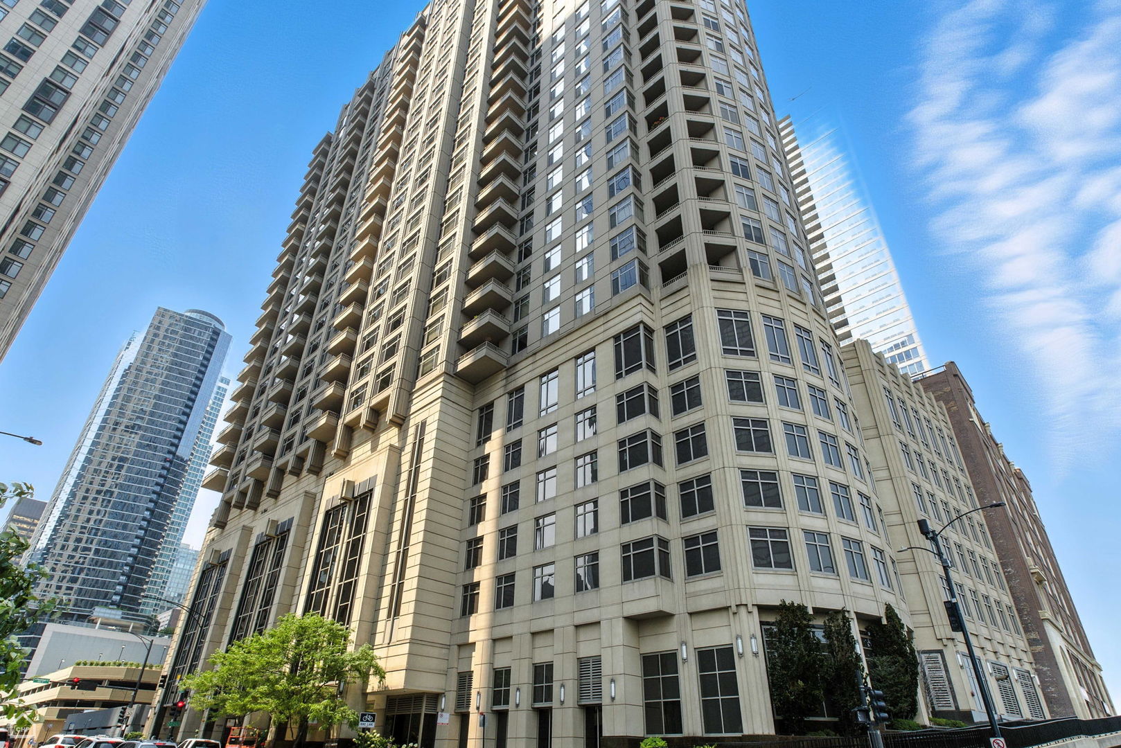 Experience elevated city living in this immaculate 2-bedroom, 2-bathroom residence with private balcony showcasing stunning lake views and attached garage parking available for an additional $40K. Step into a formal entryway that leads to a fully renovated chef's kitchen, featuring rich, dark wood cabinetry that extends to the ceiling, sleek stainless steel GE appliances including a gas cooktop, built-in oven, French door refrigerator, and dishwasher. A striking white quartz breakfast bar with seating for four, accented by globe pendant lighting, anchors the space, while a matching quartz backsplash creates a seamless, refined aesthetic. The expansive living and dining area offers breathtaking panoramic views of the city skyline, lake, and beach, and opens to a private covered 10' x 8' balcony. A custom-built entertainment center adds a sophisticated focal point and provides abundant storage. Refinished gray-washed floors, quartz windowsills, and elegant crown molding further enhance the home's modern, yet timeless appeal. The luxurious primary suite impresses with a spacious, professionally organized walk-in closet illuminated by a statement chandelier. The spa-like ensuite bath, fully reimagined in 2024, features a white oak double vanity, an enlarged glass-enclosed shower styled in white porcelain tile with gold veining, matching the porcelain flooring, and a custom built-in storage closet with makeup vanity. A generously sized second bedroom is ideally positioned near the second full bath, perfect for guests or a home office. An oversized laundry/utility room includes a side-by-side washer and dryer, along with two additional closets for maximum storage. Residents enjoy an array of resort-style amenities including a rooftop sundeck, party room, state-of-the-art fitness and business centers, and 24-hour door staff. Located steps from Navy Pier, the Lakefront Path, and iconic Michigan Avenue, this is Chicago living at its finest.
