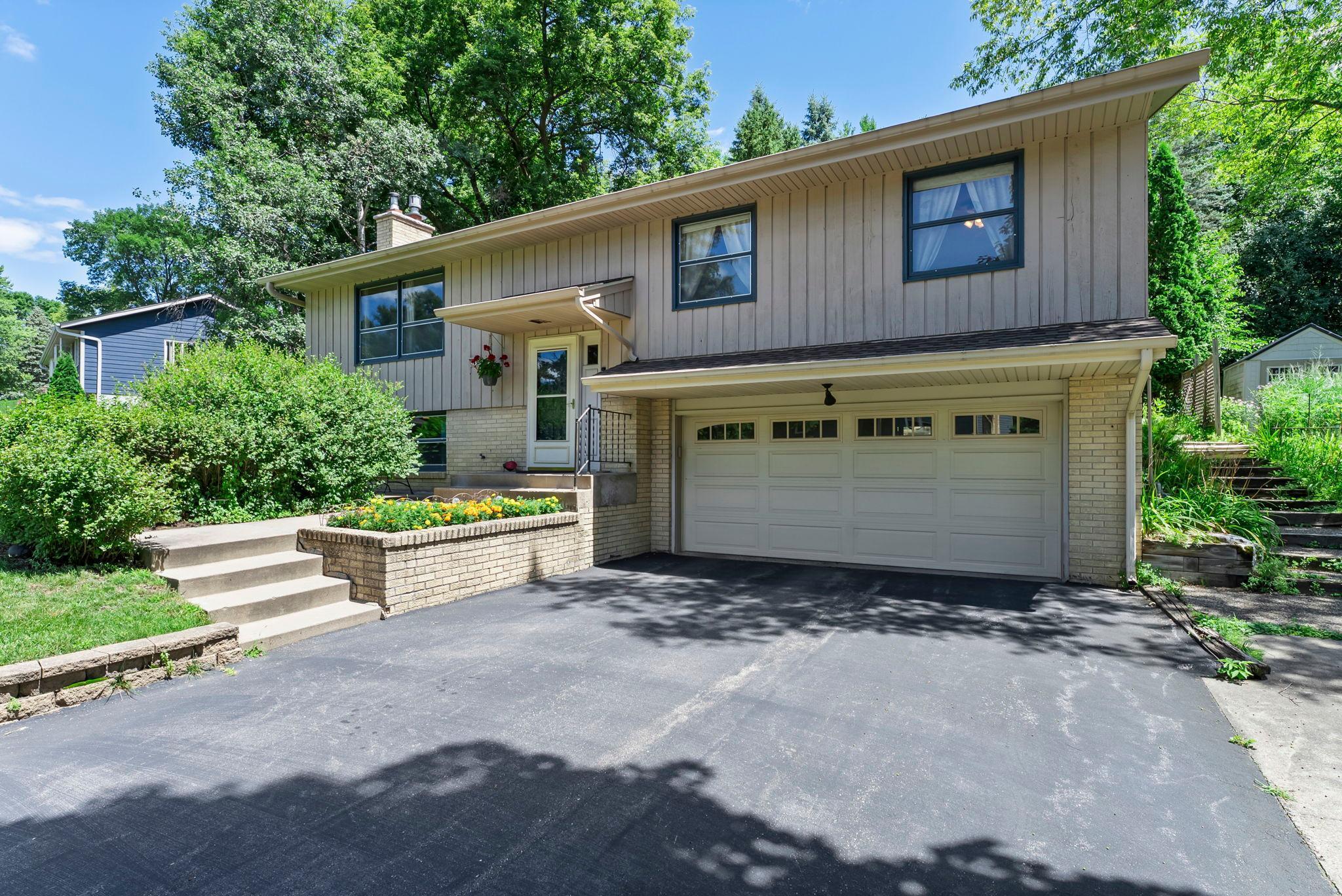Welcome to this beautifully updated 3-bedroom, 2-bathroom home tucked into a peaceful, tree-lined neighborhood just steps from Boulder Creek Park and Purgatory Creek. Located in the highly sought-after Minnetonka School District, this home offers a perfect blend of nature, convenience, and comfort.

Inside, you’re welcomed by a bright and airy living room with rich wood floors, large windows, and a cozy wood-burning stove. The dining area and stylish kitchen—with tile finishes, ample storage, and Solatube skylights—make everyday living and entertaining a breeze. A sun-filled 3-season porch with built-in cabinetry, tile floors, and a second fridge offers the perfect spot for relaxing or hosting guests.

The primary suite features plush carpet, a ceiling fan, a custom closet system, and an en suite bath with a walk-in tiled shower. Two additional bedrooms with wood floors and ceiling fans share a beautifully remodeled full bath. The lower-level offers additional living space, including a family room with a gas stove, generous storage including a cedar closet, and a spacious laundry area nearby.

Step outside to a beautifully landscaped yard with a two-tier patio, built-in gas line for your grill, swing, shed, and peaceful front patio. With an attached 2-car garage, countless updates—including a new roof, HVAC, and water heater—and a location that checks every box, this gem is one you won’t want to miss!